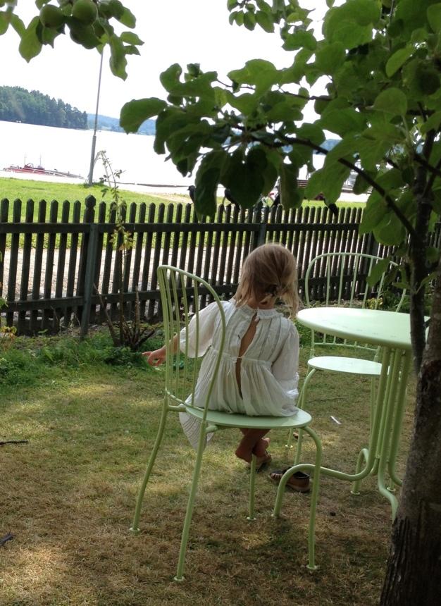 Flickan under äppelträdet blickar ut över sjön.