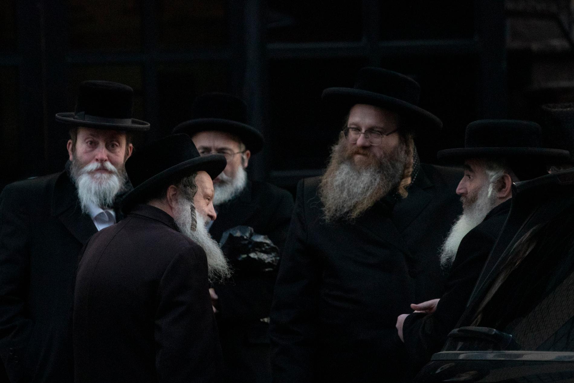 Ortodoxa judiska män samlade utanför Brooklyns synagoga inför begravningen av Mosche Deutsch som dog under tisdagens skjutningar i Jersey City.