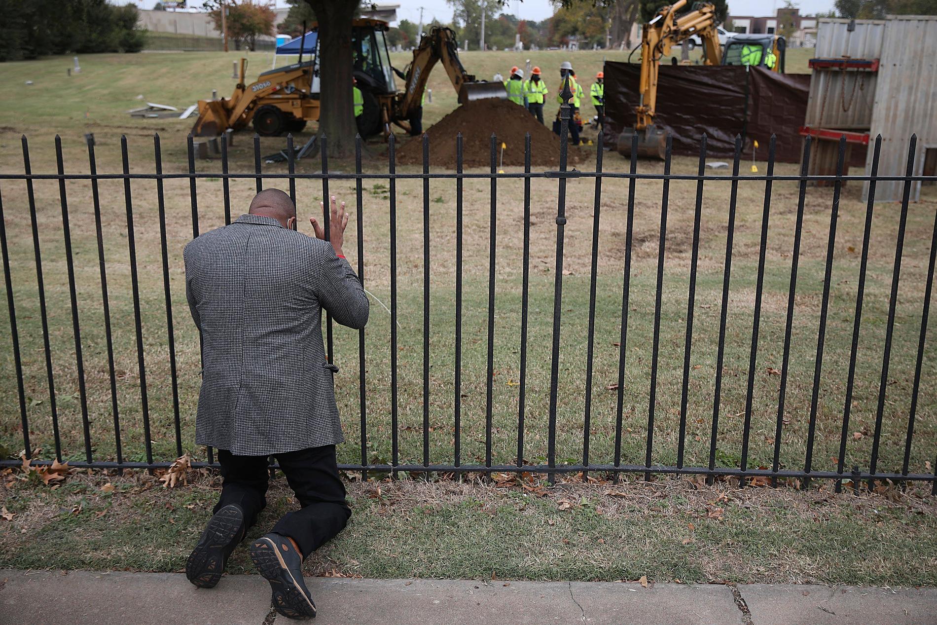 Robert Turner, pastor vid kyrkan Vernon A.M.E. i Tulsa, knäböjer i bön vid Oaklawn Cemetery medan arkeologer letar efter kvarlevor efter offren för massakern 1921. Bilden är från den 20 oktober.