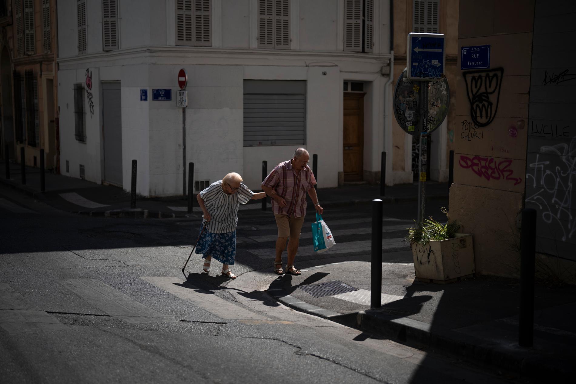 Ett äldre par hukar i extremvärmen i Marseille. Extrema temperaturer lamslår stora delar av södra Frankrike.