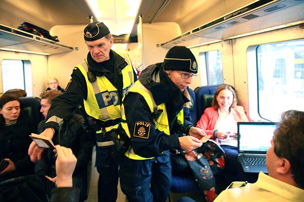 Polisen kontrollerar pass på Öresundstågen. Från och med i dag är id-handlingar ett krav för att komma ombord på tågen.