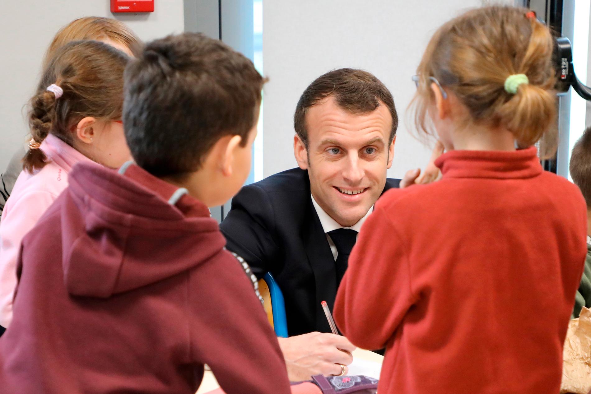 Frankrikes president Emmanuel Macron besöker elever i en skola i Saint-Sozy.
