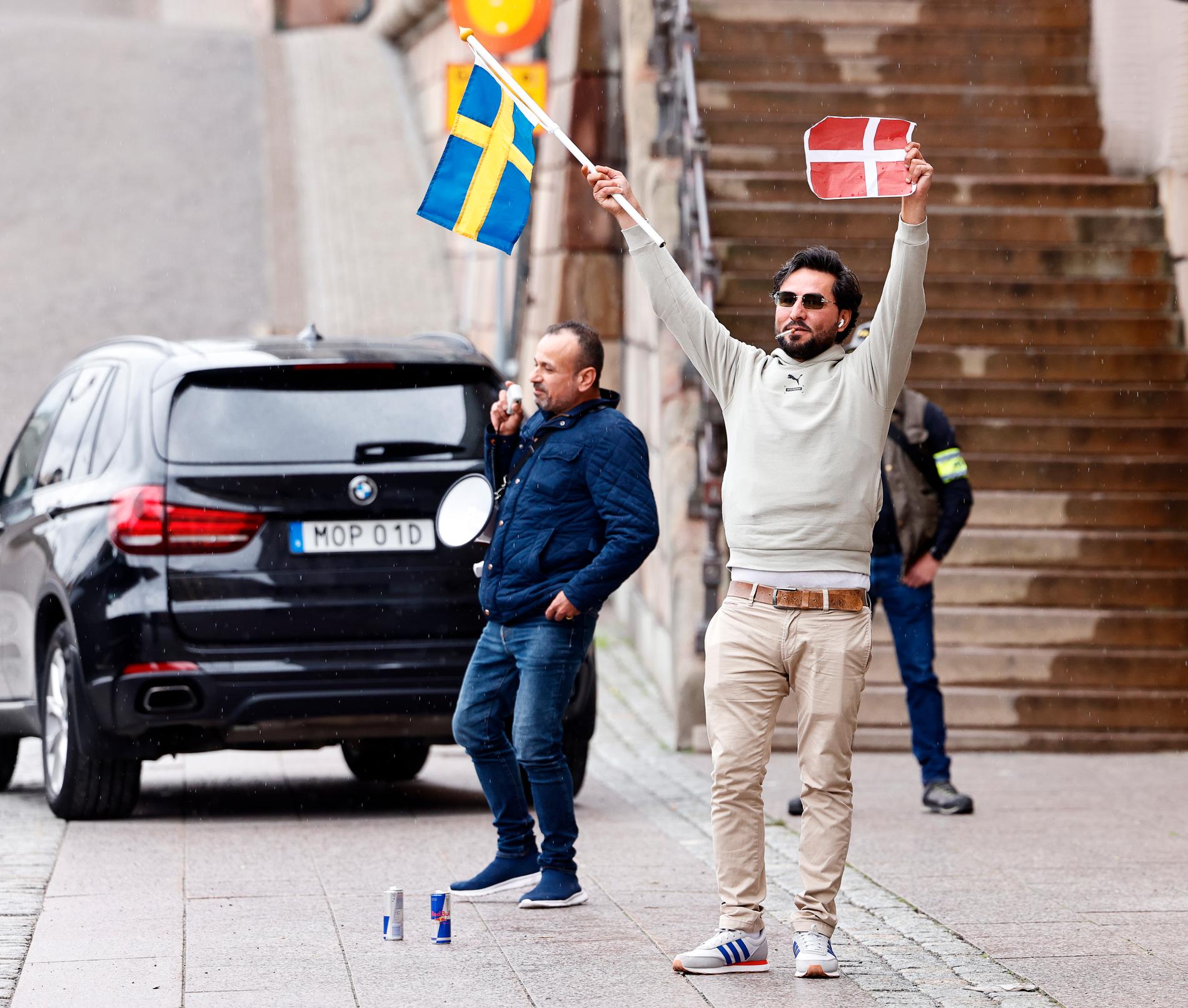 Salwan Momika håller i en svensk och dansk flagga. Tillsammans med Salwan Najem brände han en Koran vid Mynttorget i Stockholm i juli.