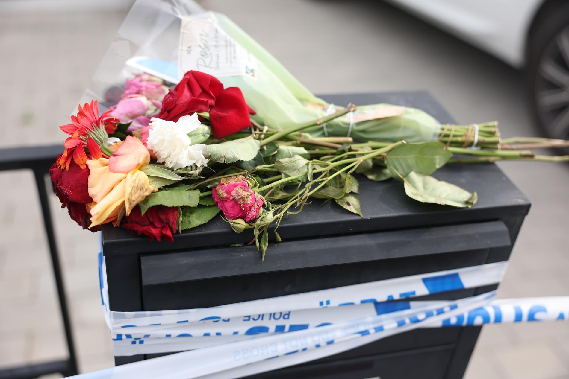 Blommor på en brevlåda efter mordet på Mogos Amanuel.