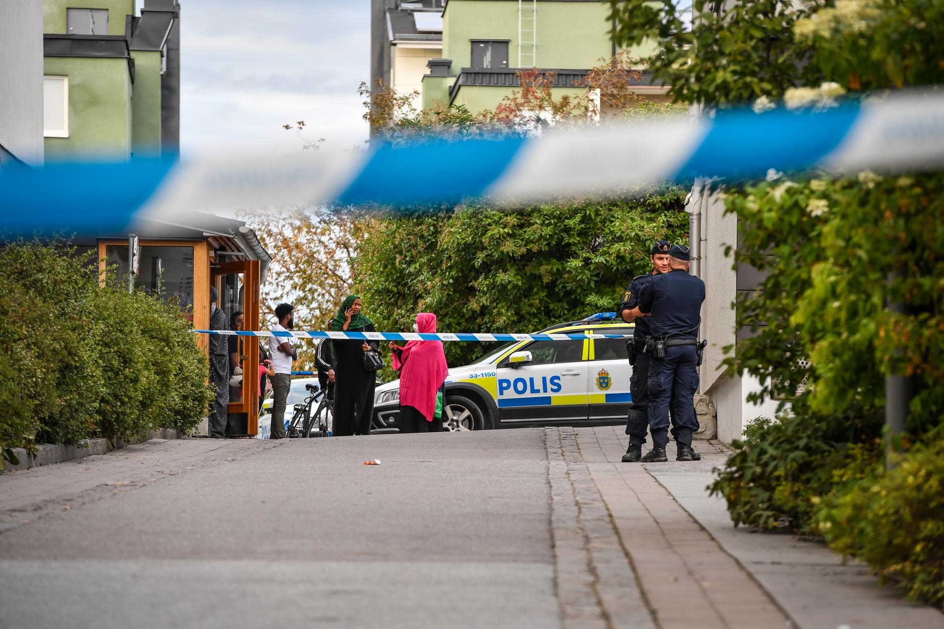 Polis vid avspärrning där en man hittats skottskadad i Husby i Stockholm i slutet av augusti 2020. Den skottskadade mannen avled senare på sjukhus. Arkivbild