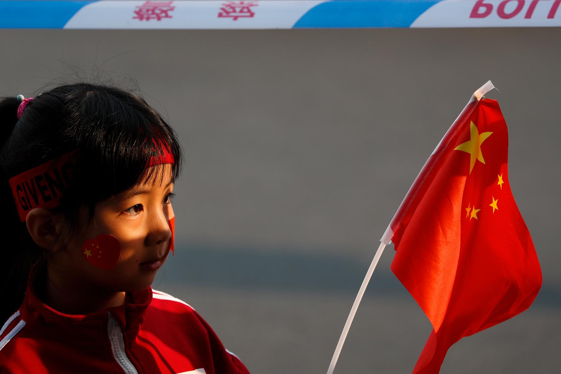 En flicka väntar på paraden i Peking som ska symbolisera 70 år av framgångar för Kina.