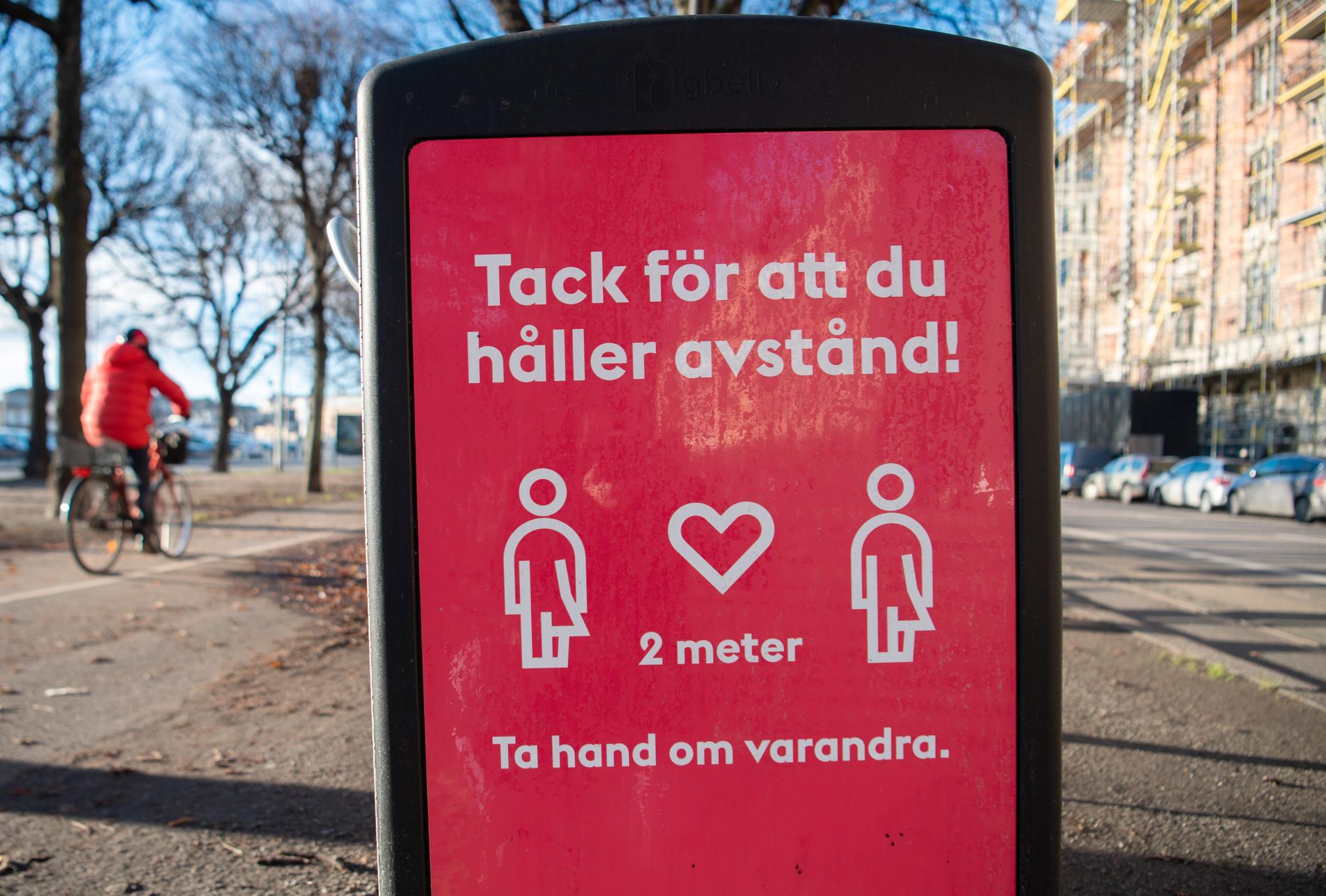 En skylt på en soptunna på Strandvägen i centrala Stockholm uppmanar människor att hålla avstånd. Arkivbild.