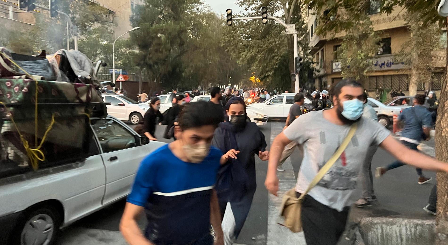 Teheran, Iran. Folk flyr undan kravallpolisen under en demonstration till stöd för Mahsa Amini. 
