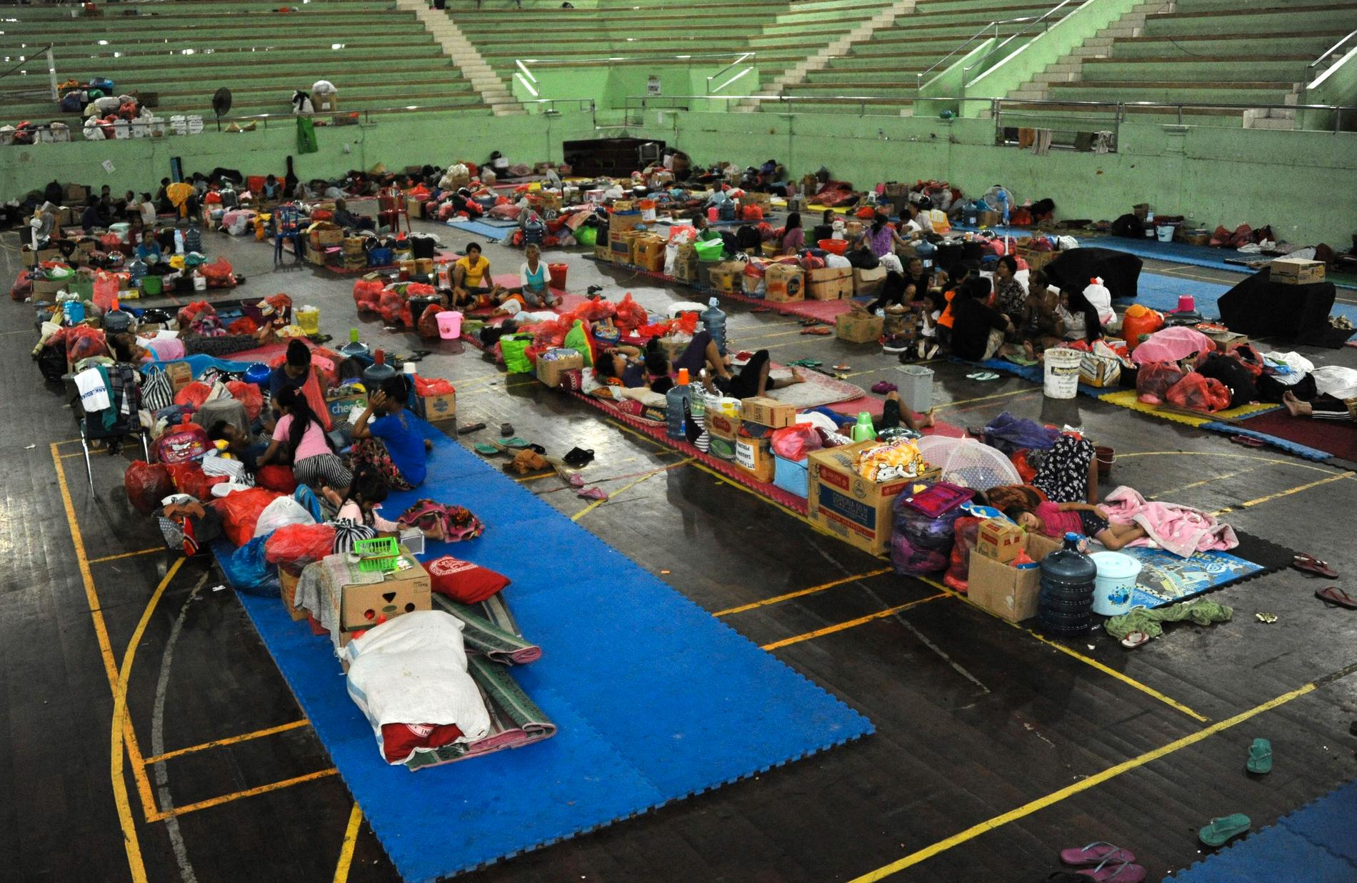 Ortsbor som evakuerats ur närområdet sover uppehåller sig i en stor gympasal.