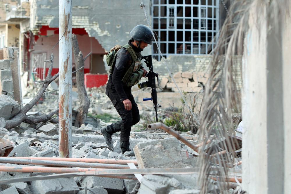 En elitsoldat i irakiska armén undersöker resterna av Ramadi