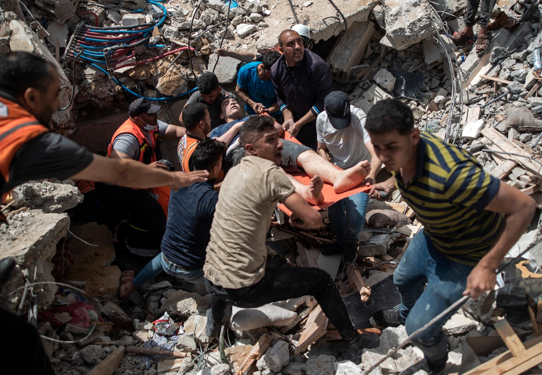 På bilden syns hur palestinsk räddningstjänst har grävt fram en överlevare från en av Israels bombningar i Gaza.