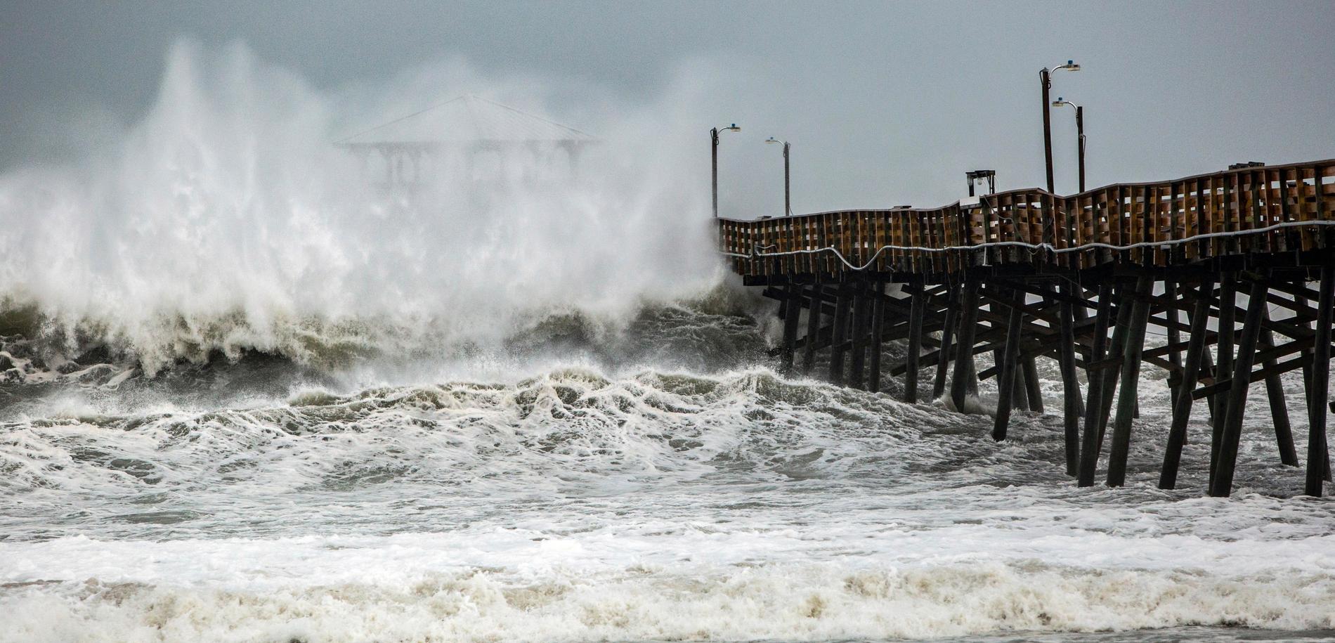 Kraftiga vågor slår in över en pir i Atlantic Beach i North Carolina.