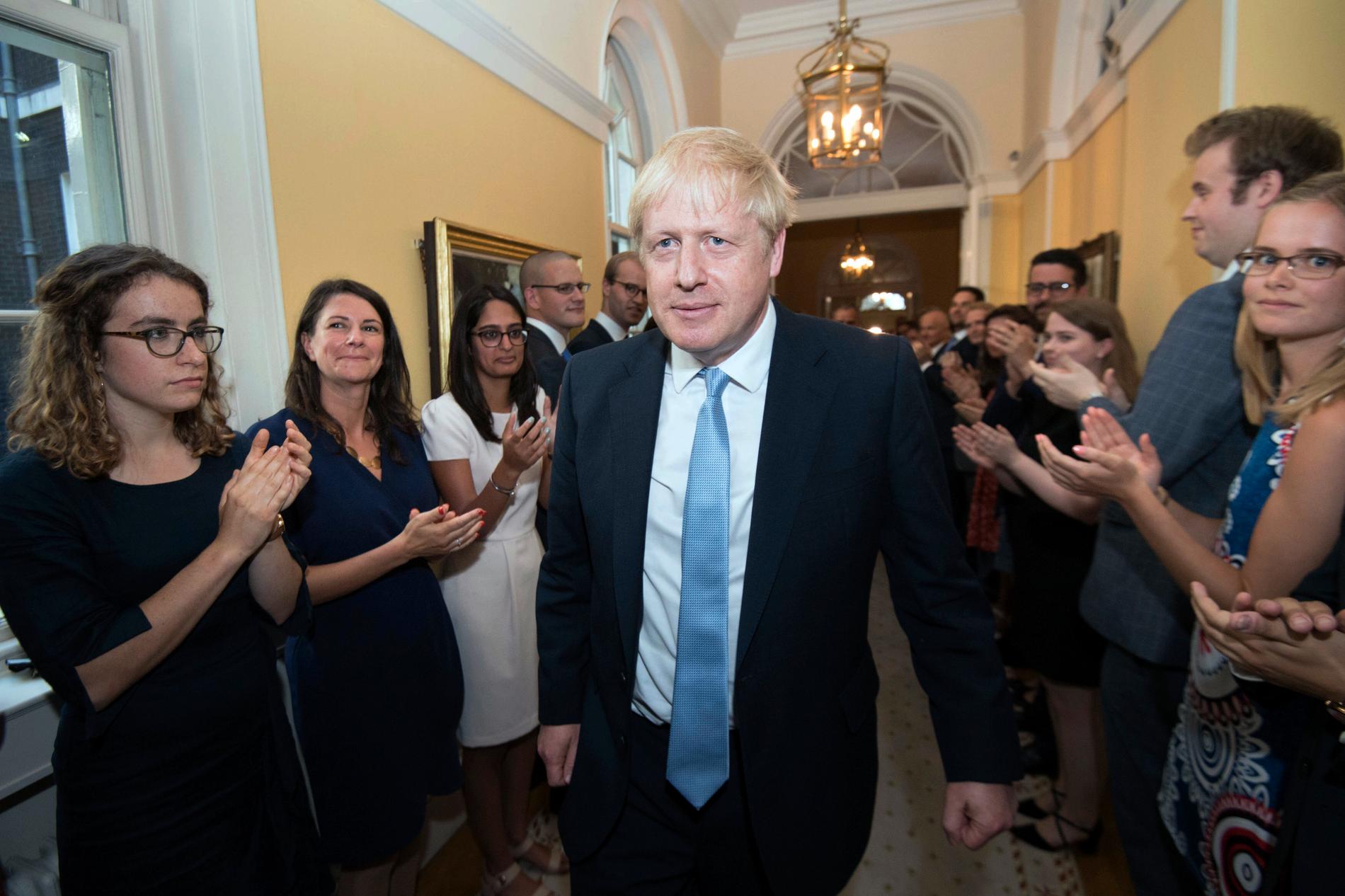 Premiärminister Boris Johnson välkomnas av personalen på 10 Downing Street.