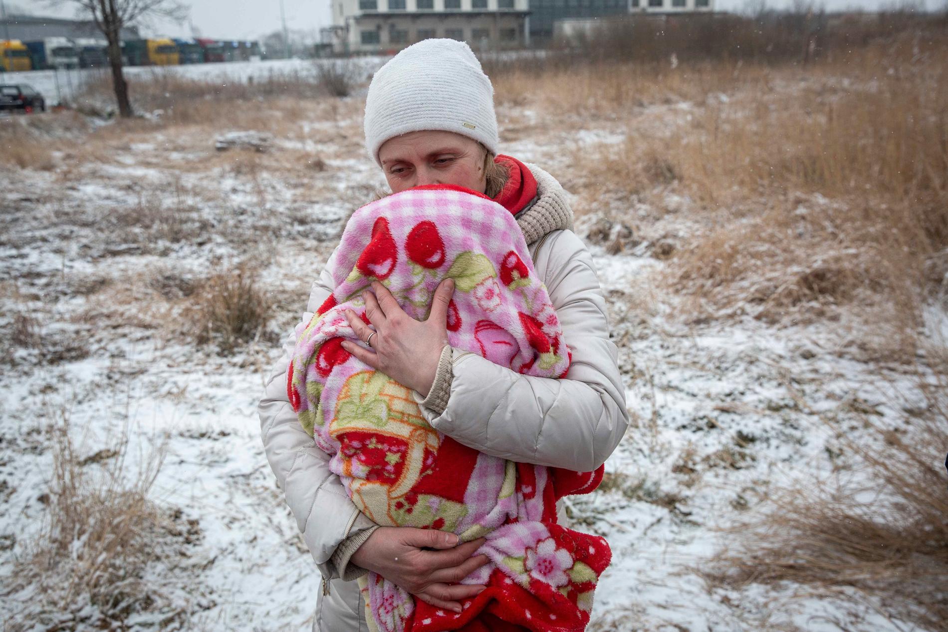 Axana Opalenko, 42, håller om Meron, 2 månader gammal för att hålla värmen efter att just ha passerat gränsen till Polen.