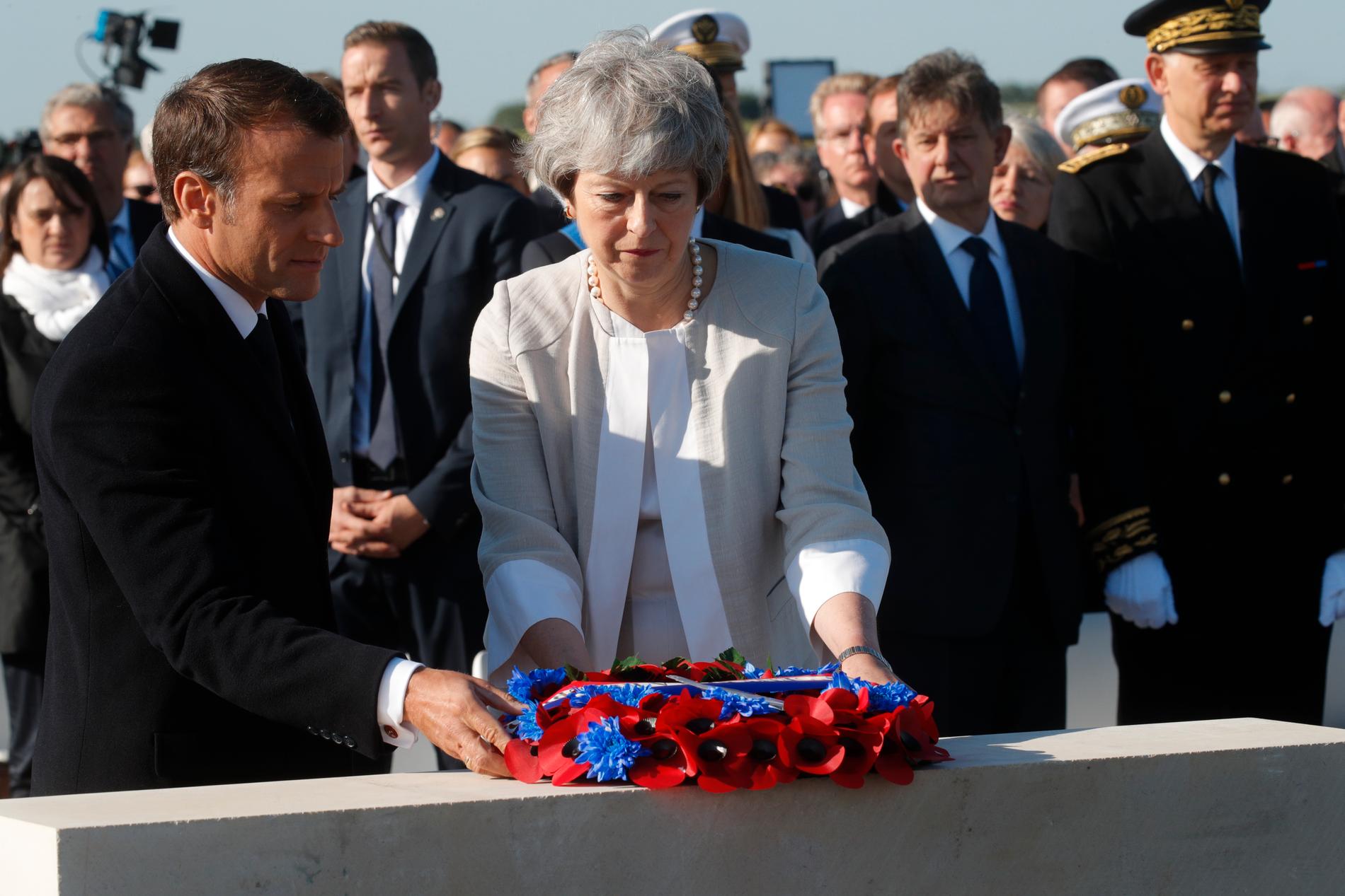 Storbritanniens premiärminister Theresa May och Frankrikes president Emmanuel Macron lägger en krans vid minnesceremonin för de brittiska stupade under D-dagen.
