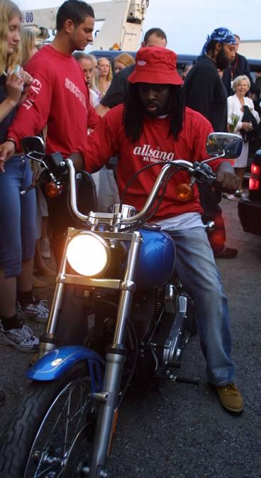 Wyclef Jean drog iväg på en blå Harley Davidson som han lånat.