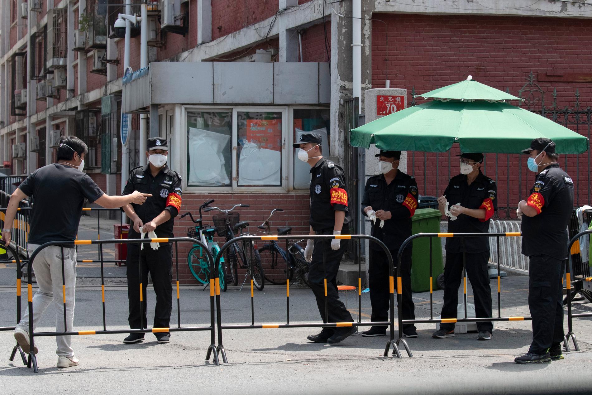 Säkerhetspersonal vid ett kvarter som stängts ned i Peking i samband med ett utbrott av det nya coronaviruset.
