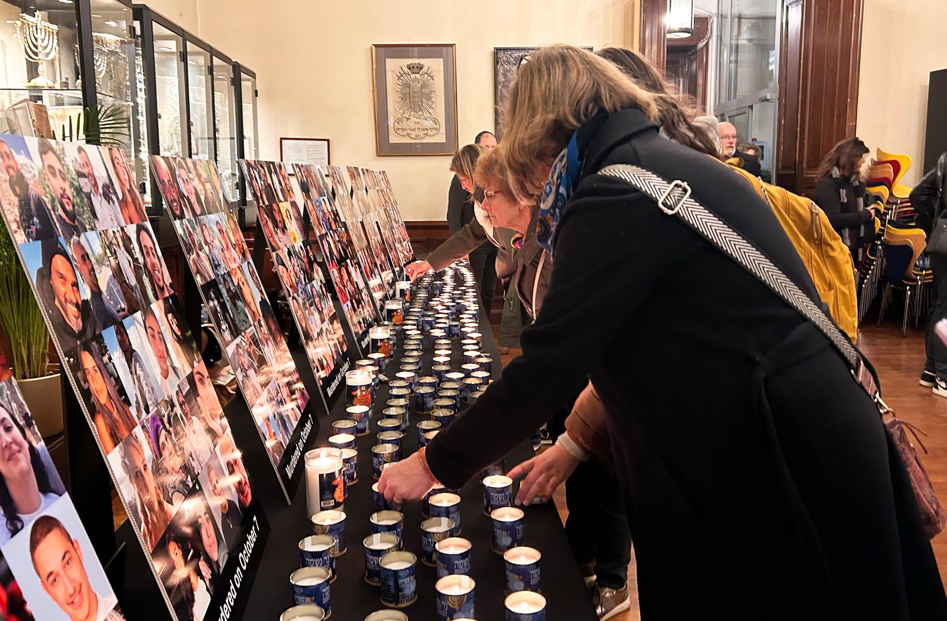 Besökarna tänder ljus för att hedra alla som dödades i terrorattacken den sjunde oktober.