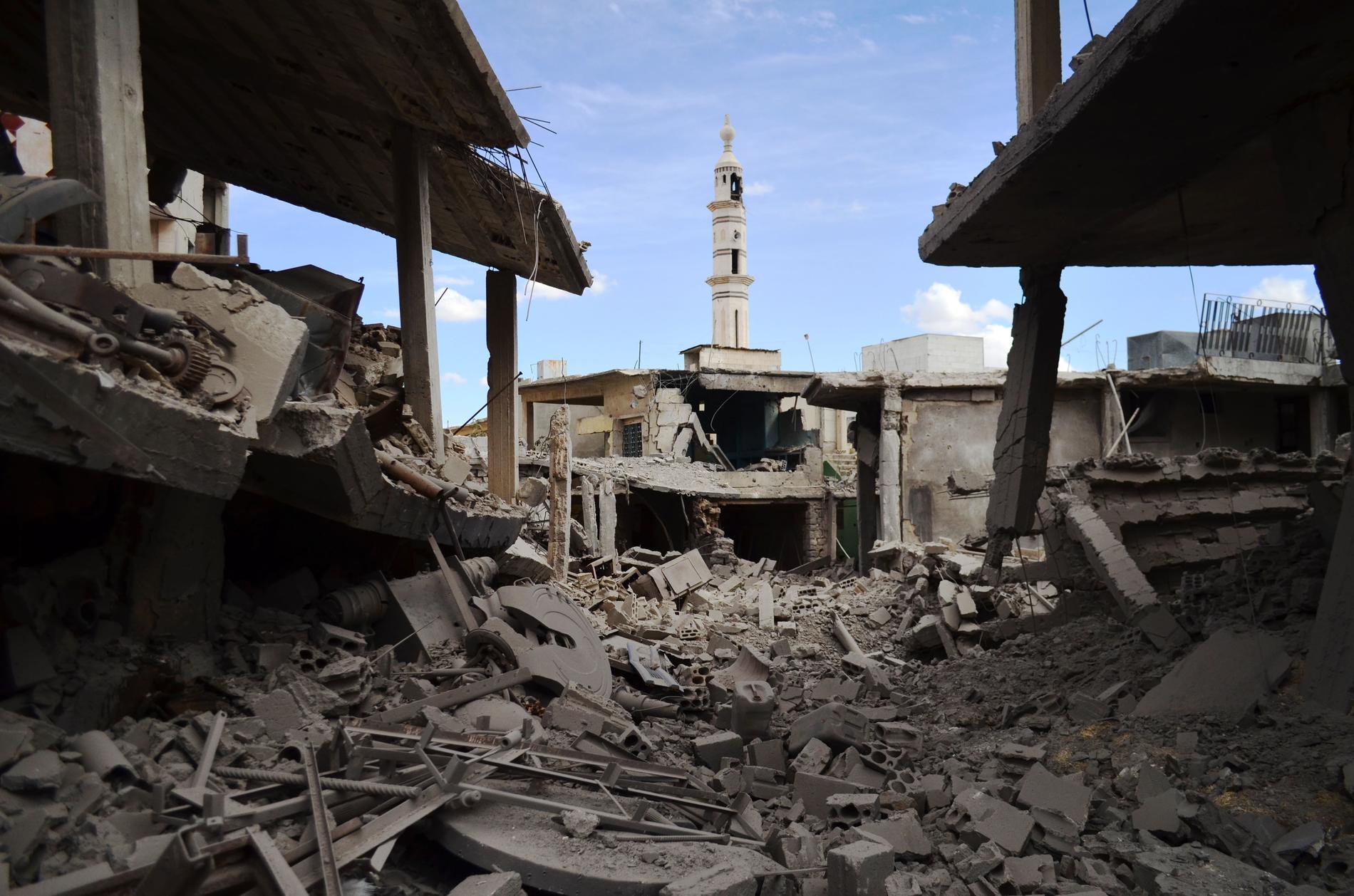 Förstörda byggnader och ett minaret i Homs efter ett flyganfall.