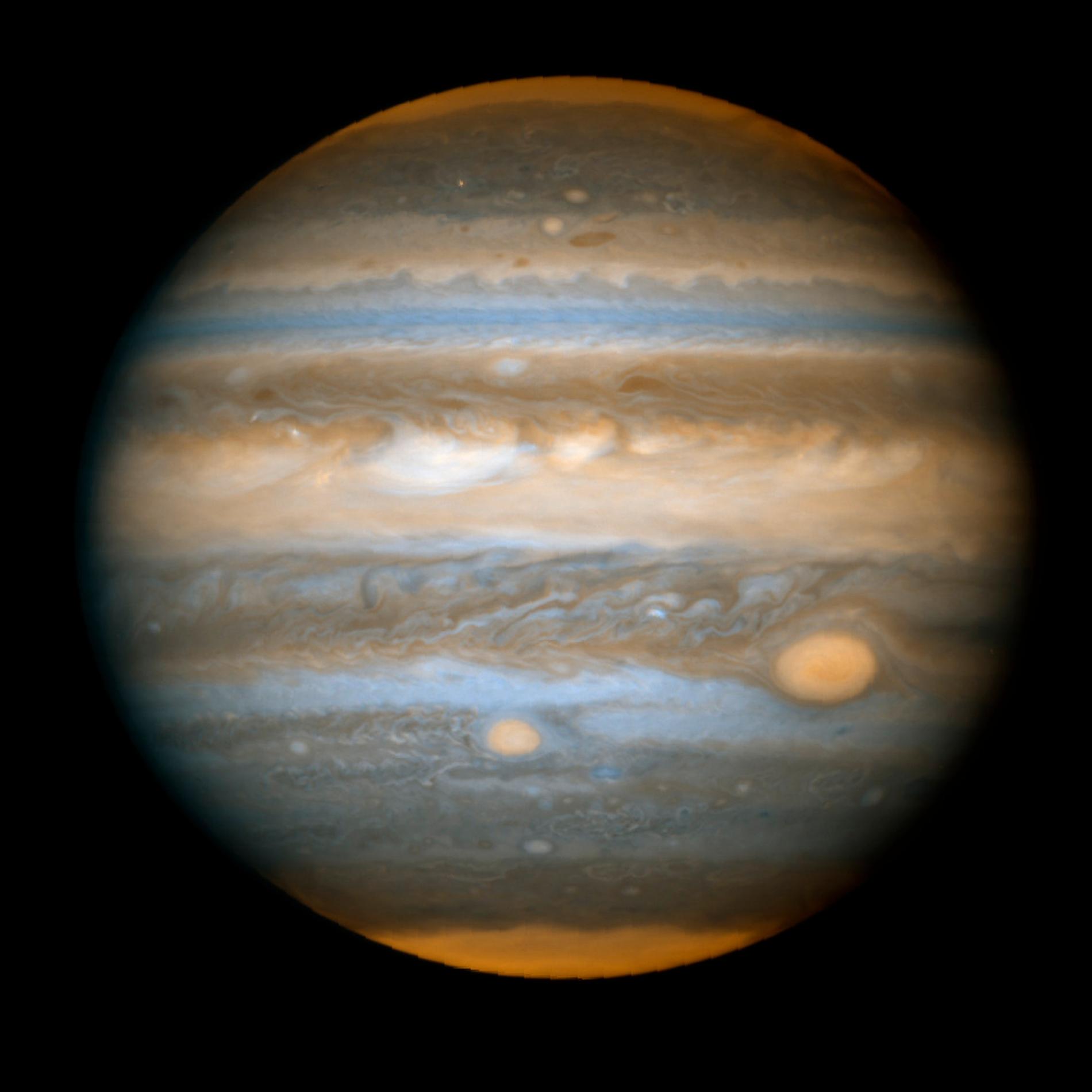 Jupiter sedd från Nasas hubbleteleskop i maj 2006. De röda fläckarna som syns på ytan är stormsystem i planetens atmosfär.