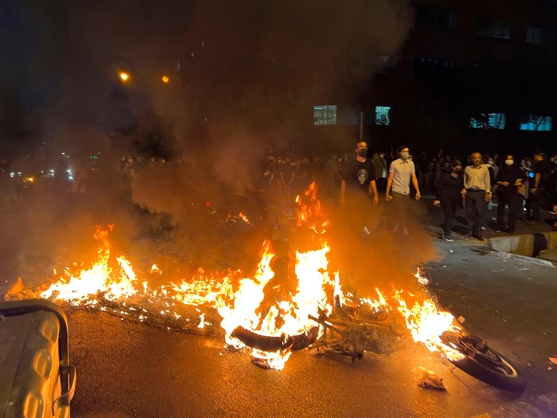  En polismotorcykel brinner under en protest i centrala Teheran i Iran under måndagen den 19 september.