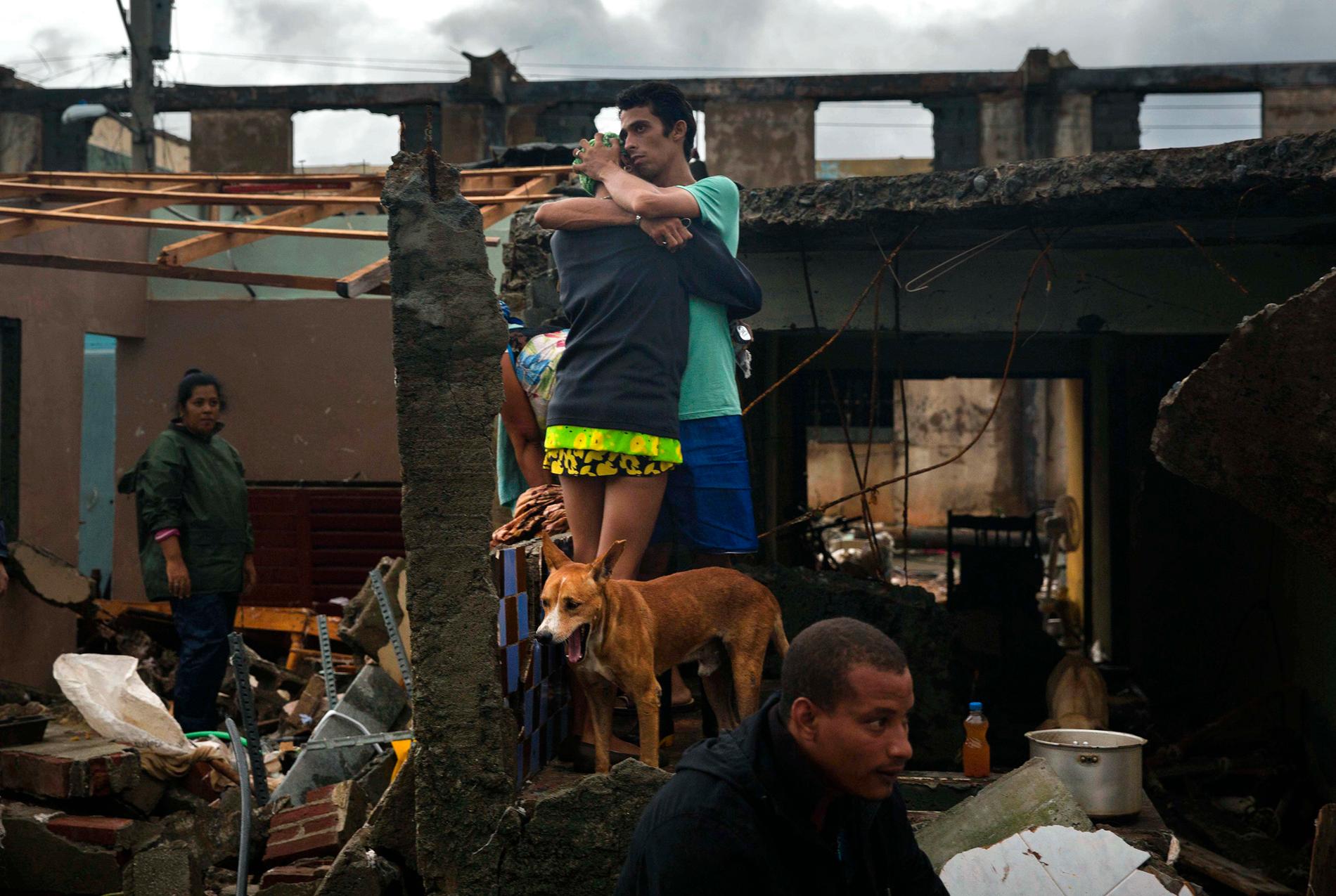 Ett par kramar om varandra efter att deras hem i Baracoa på Kuba förstörts av orkanen Matthew.