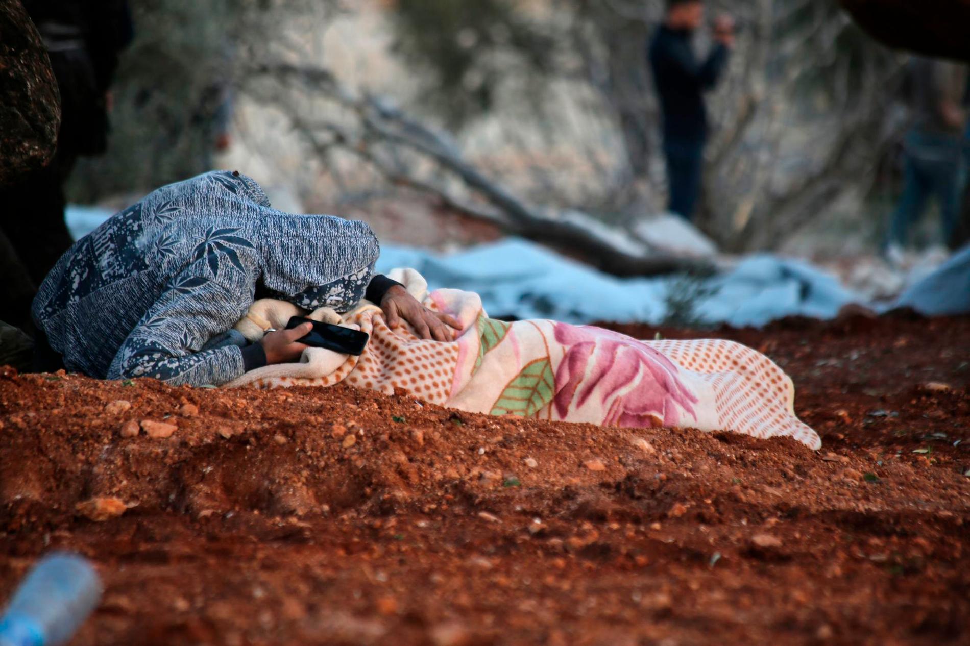 En syrier sörjer sin döda mor efter en flygattack mot deras hem i Sarmin i Idlib den gångna helgen.