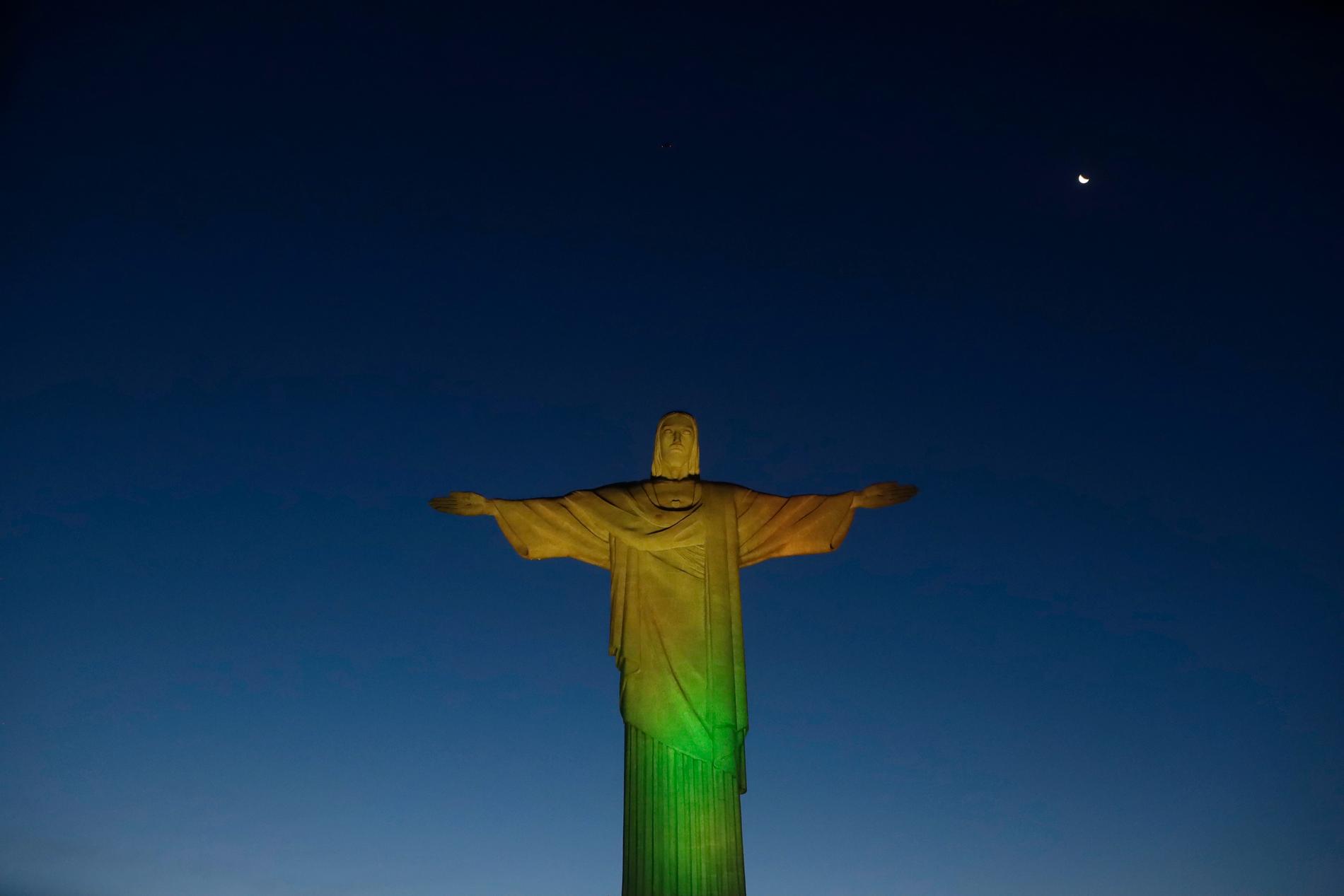 Karnevalen i Rio de Janeiro ställs in, då det inte bedöms vara möjligt heller i juli. Här har Jesusstatyn på den så kallade Sockertoppen lysts upp för att markera vaccinstarten tidigare i veckan.
