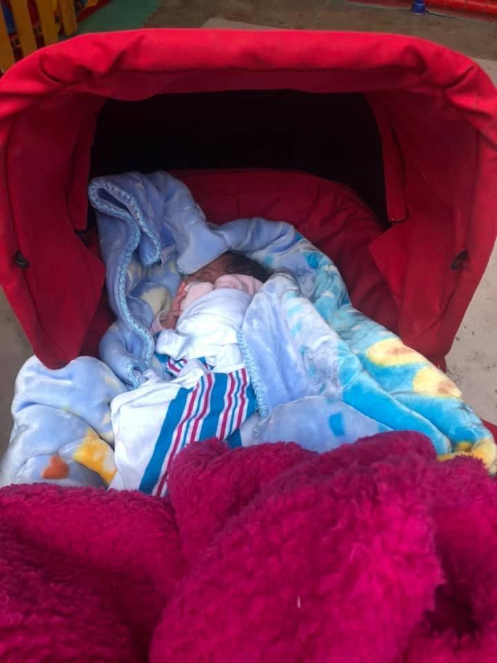Små barn får sova på blöta filtar på marken i lägret. En barnvagn ger en varm sovplats. 
