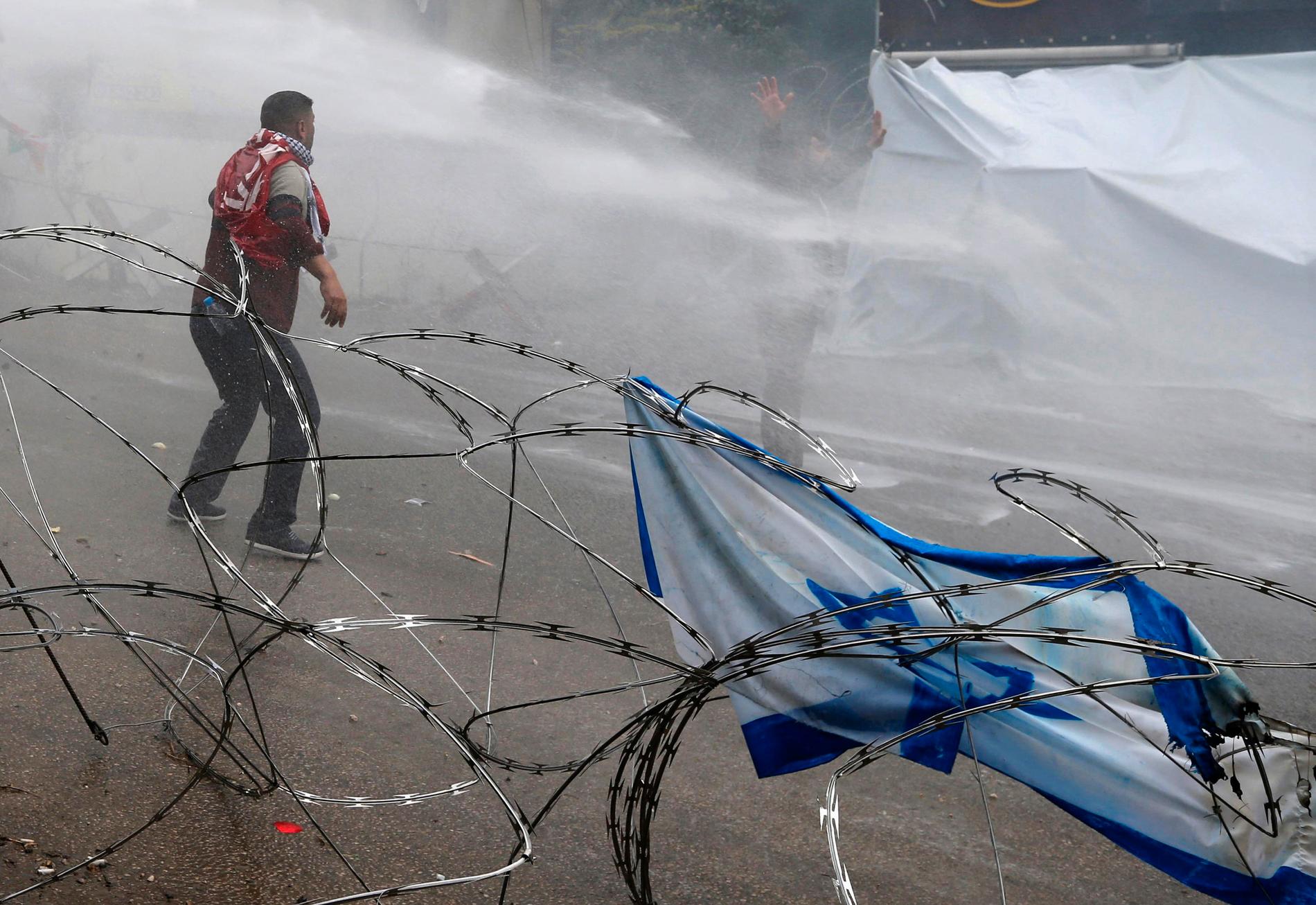 Demonstranter sprutas ner med vatten nära den amerikanska ambassaden i Beirut.