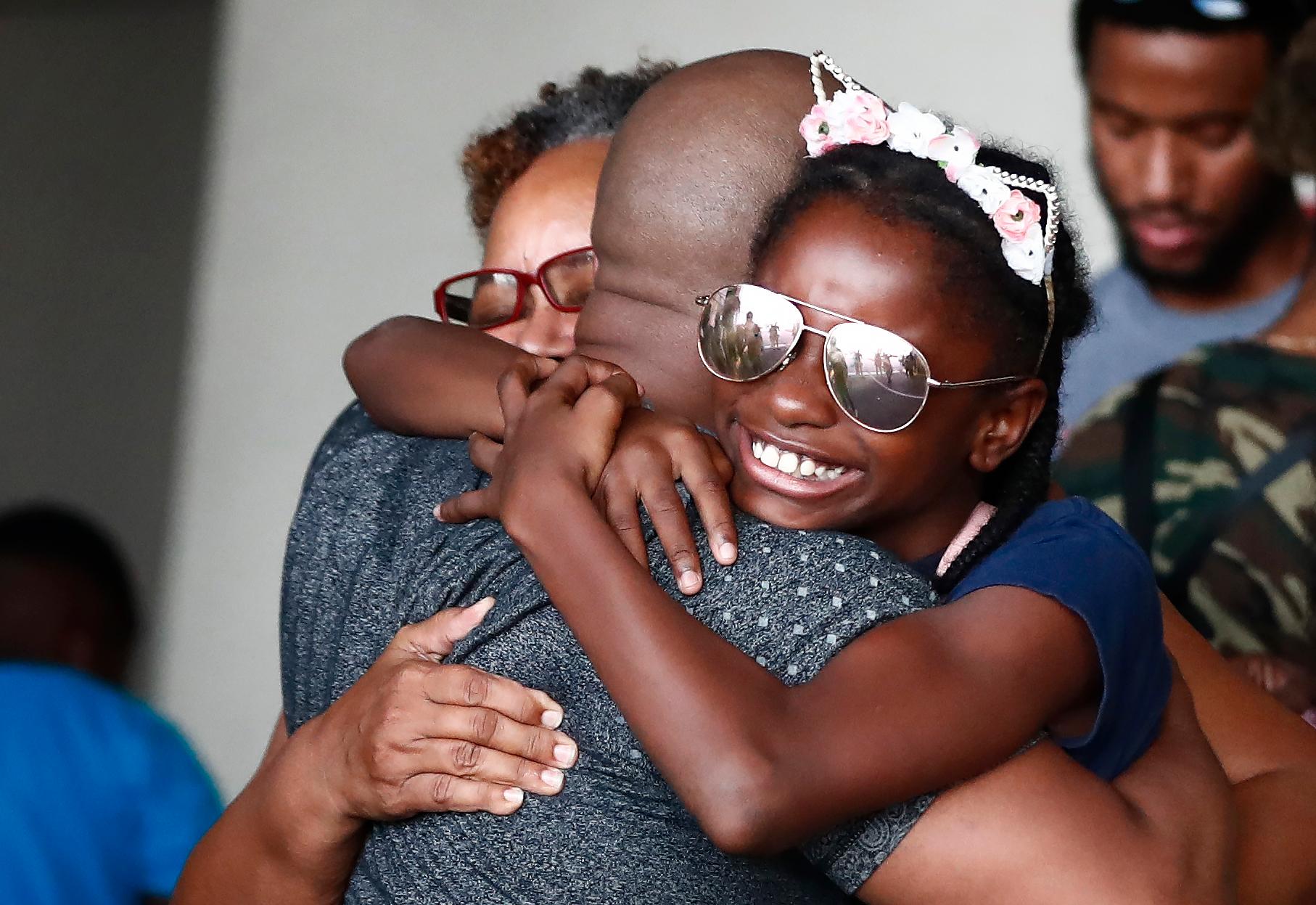 Mark Winder kramar om sitt syskonbarn Gabriella Winder, 10, och sin mamma Marcia Winder efter att de båda räddats från Freeport som drabbades hårt av orkanen Dorian.