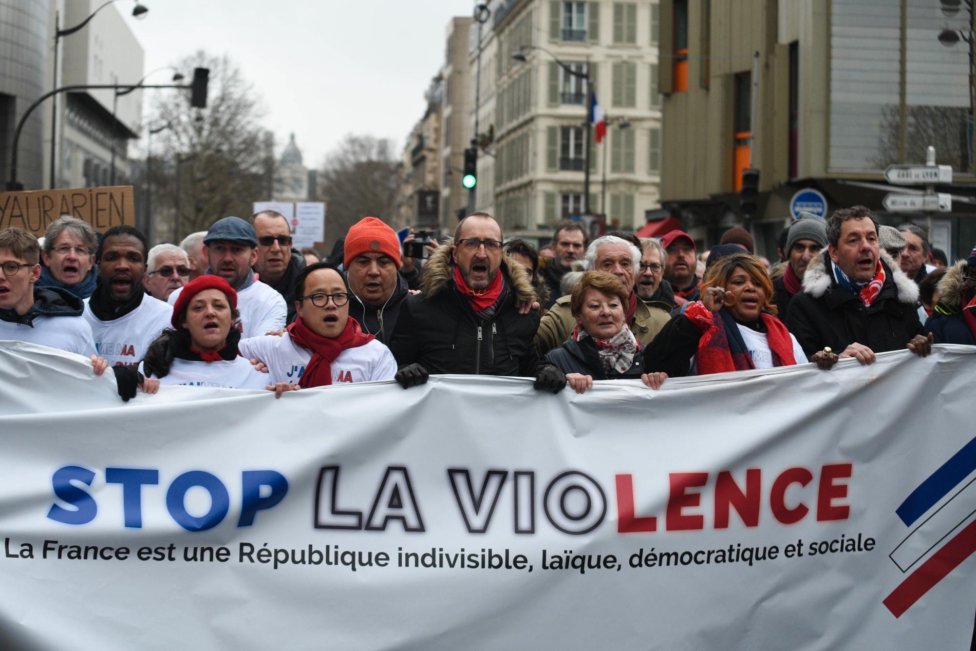 Philippe Lhoste, andra person från vänster, och Laurent Soulie, i mitten, deltar i av Röda sjalarnas manifestationer mot Gula västarna. Budskap som ropades ut var bland annat "tack polisen", "vi är också folket", "stoppa våldet" och "revolution nej, demokrati ja".