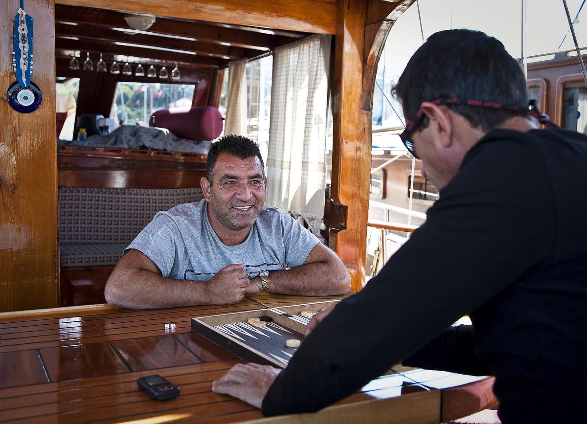 ”Våra gäster vill ha och lugn och ro ... och ett blått hav”, säger kapten Ali Tintas, 49. Ali tar ett parti backgammon tillsammans med kapten Coco på besök från grannbåten.