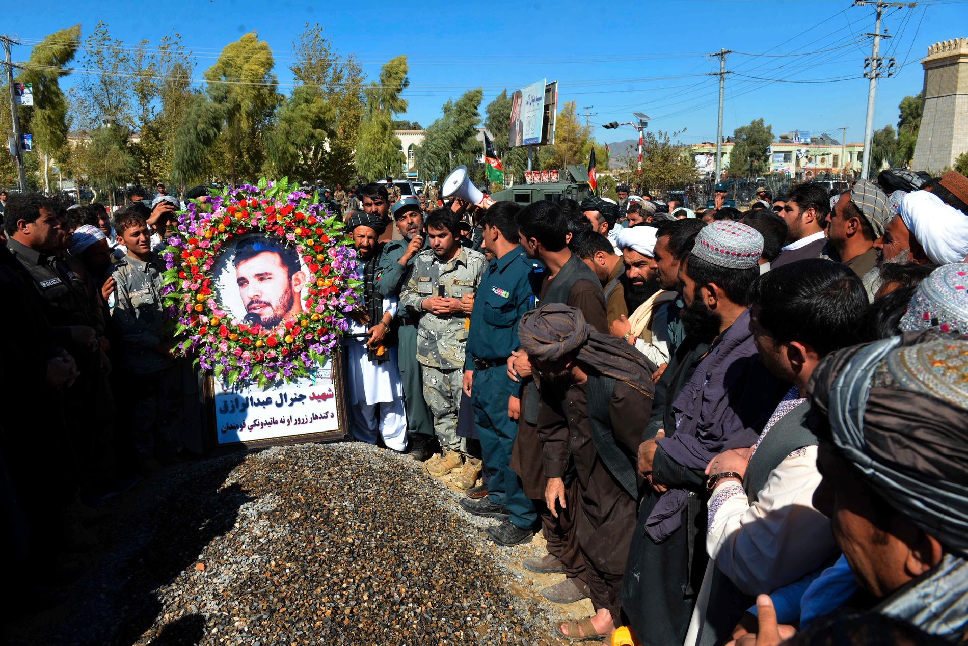 Sörjande civila och militärpersonal vid den mördade polischefen Abdul Raziqs grav vid en ceremoni i Kandahar i förra veckan.