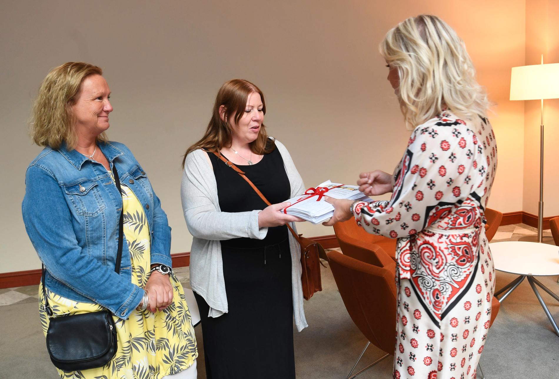 Undersköterskorna Jenny Klingstam och Mari Viberg lämnar över namninsamlingen från undersköterskeuppropet till soclailminister Lena Hallengren (S) på Socialdepardementet i Stockholm.