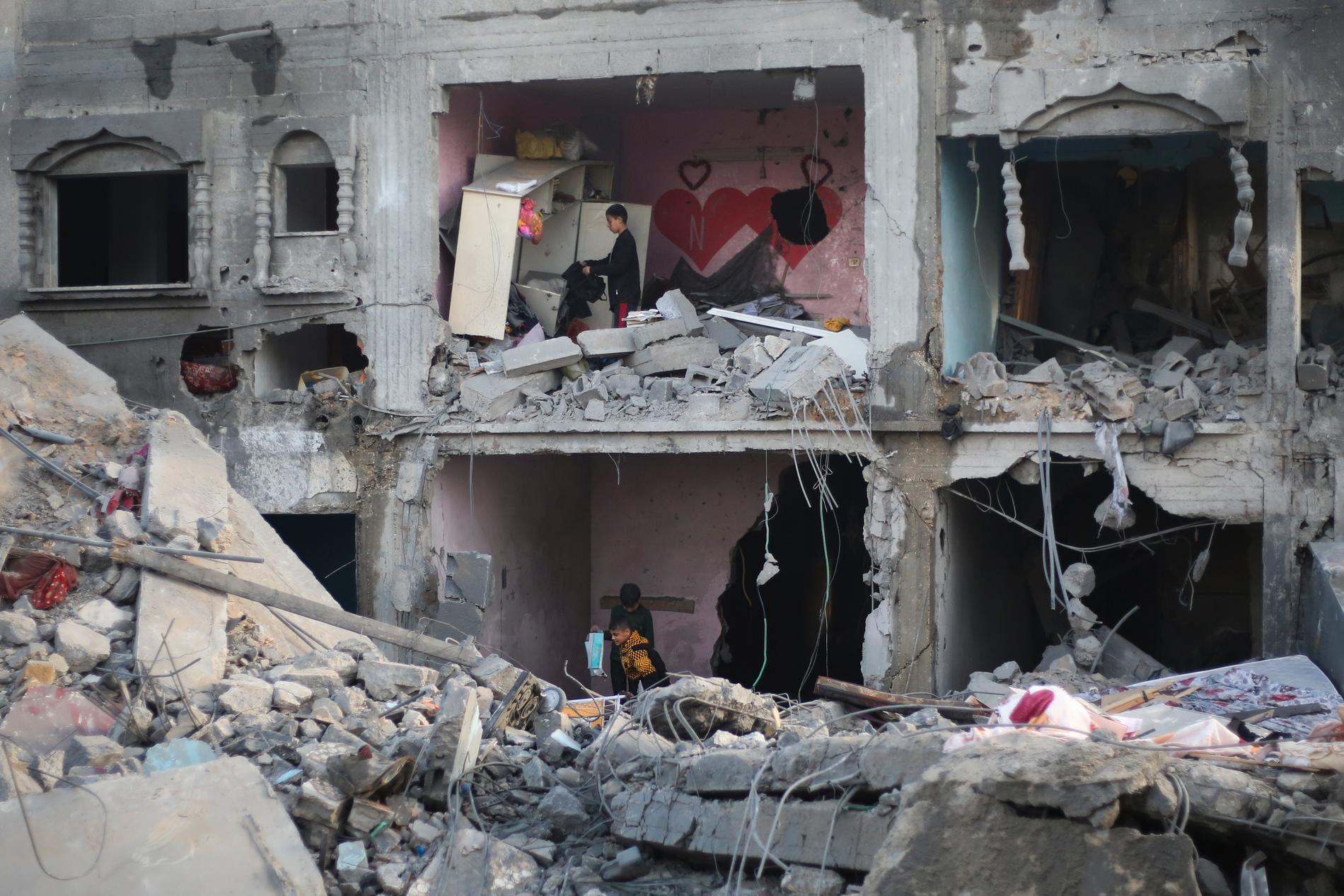 Palestinier i Rafah (södra Gaza) blickar ut över förstörelsen efter den israeliska militärens omfattande attacker natten till måndag 12 februari.