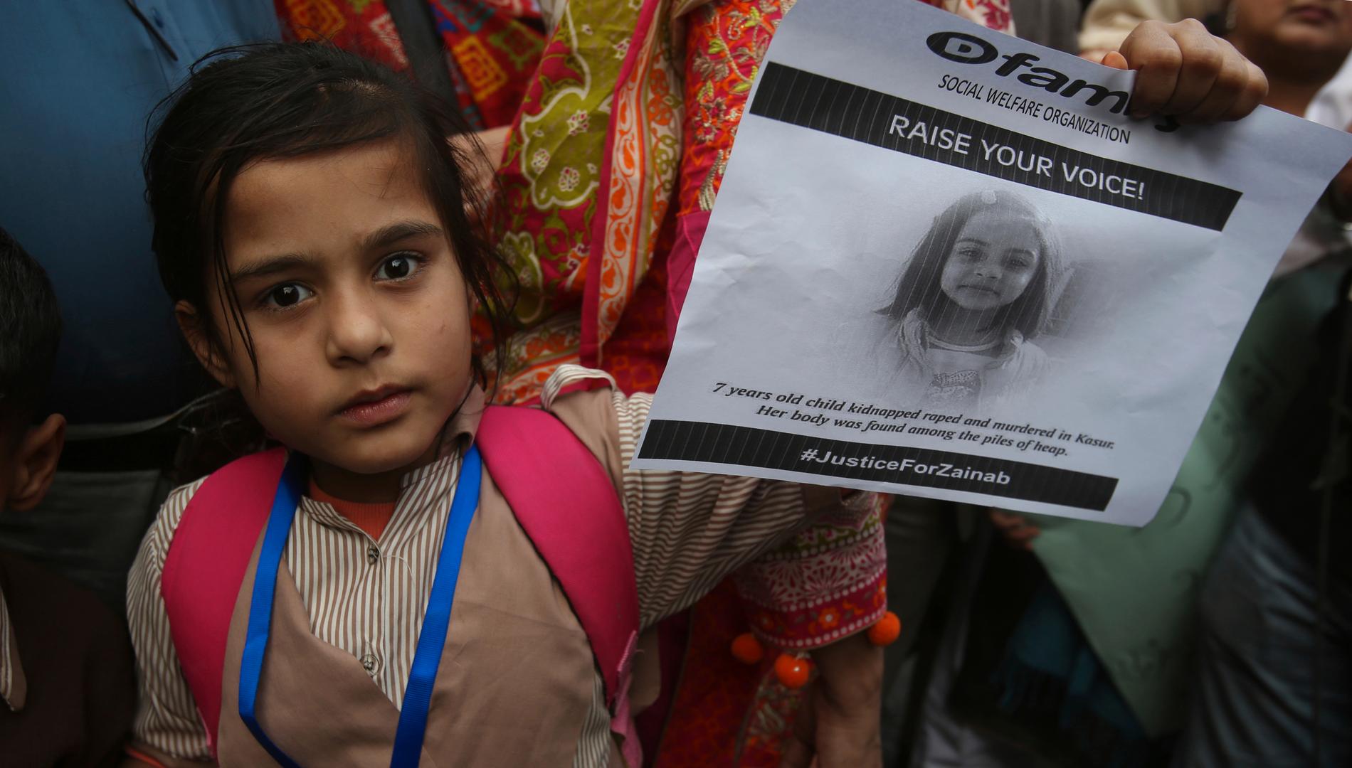 En flicka håller upp ett porträtt av den mördade Zainab Ansari.