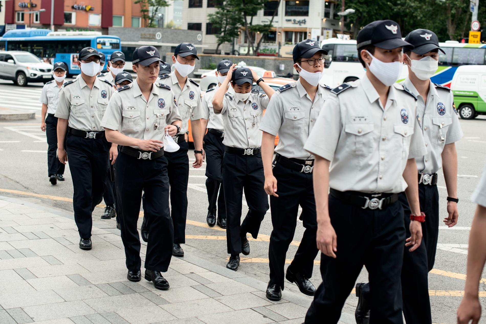 De sydkoreanska poliserna bär enhetliga uniformer – och skyddsmask för näsa och mun.