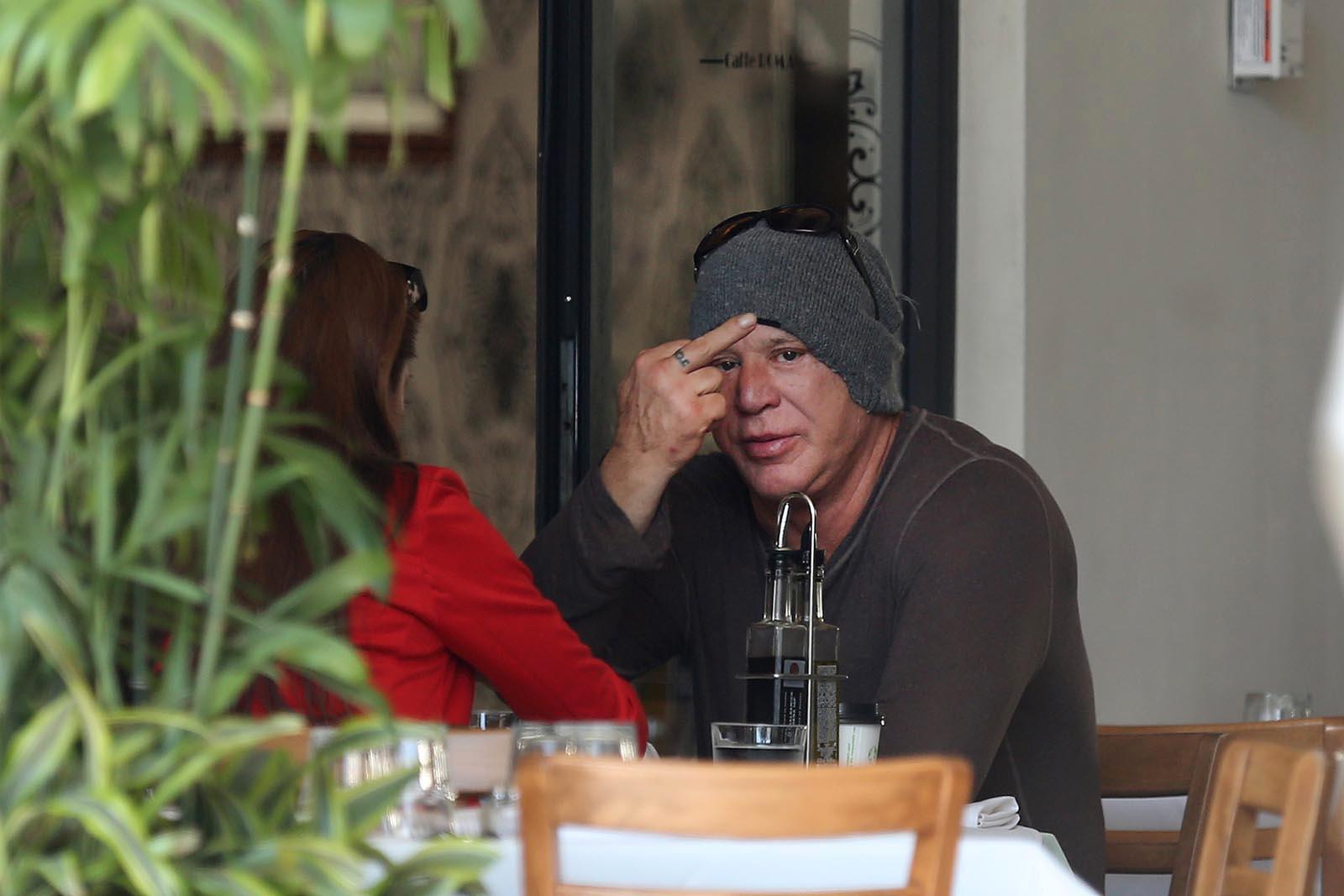 Mickey Rourke pekar fingret åt en fotograf under en lunch i Los Angeles.