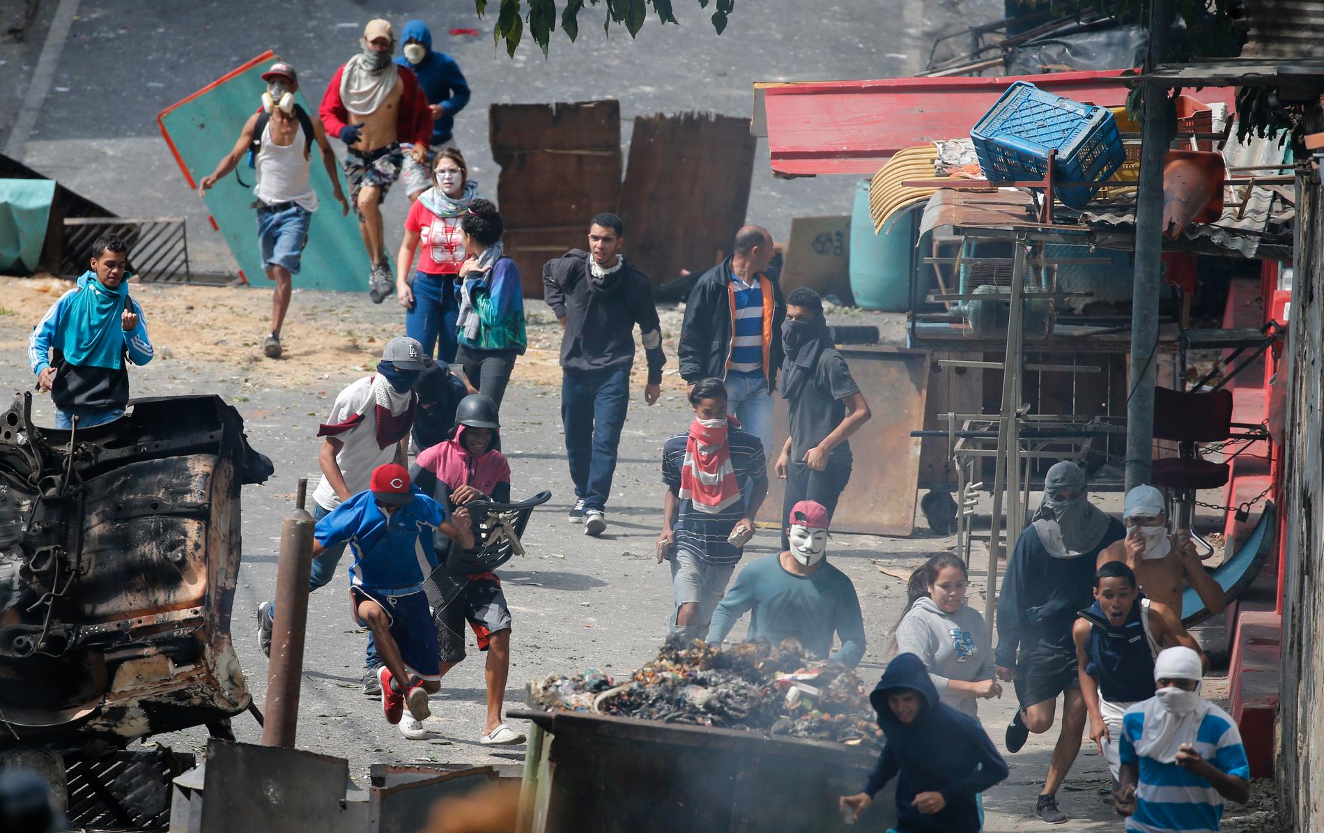 Regeringskritiska demonstranter, som sympatiserar med de gripna militärerna, drabbar samman med polis i Venezuelas huvudstad Caracas.