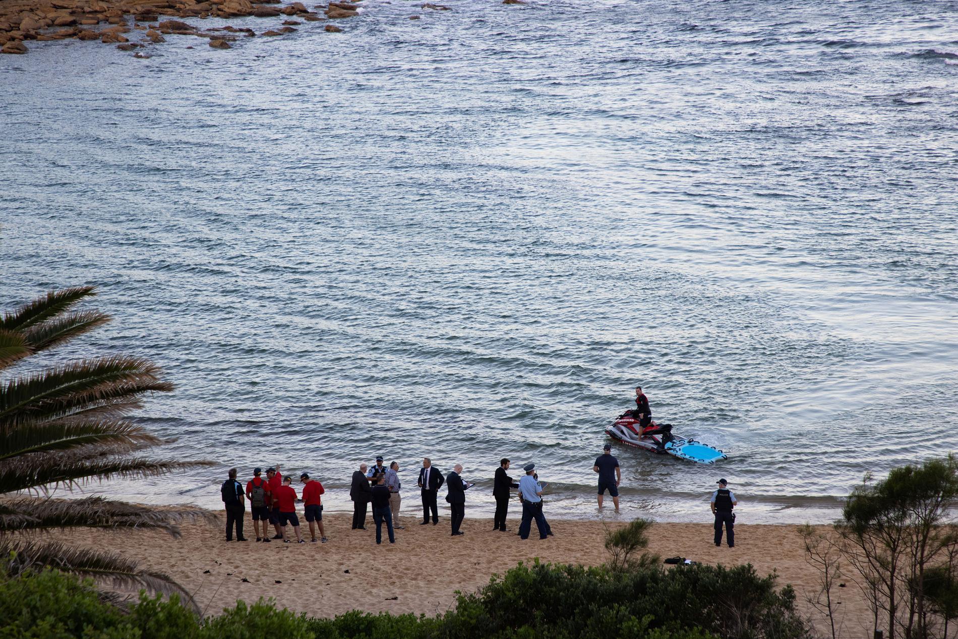 Människor samlas på stranden Little Bay där hajattacken inträffade.