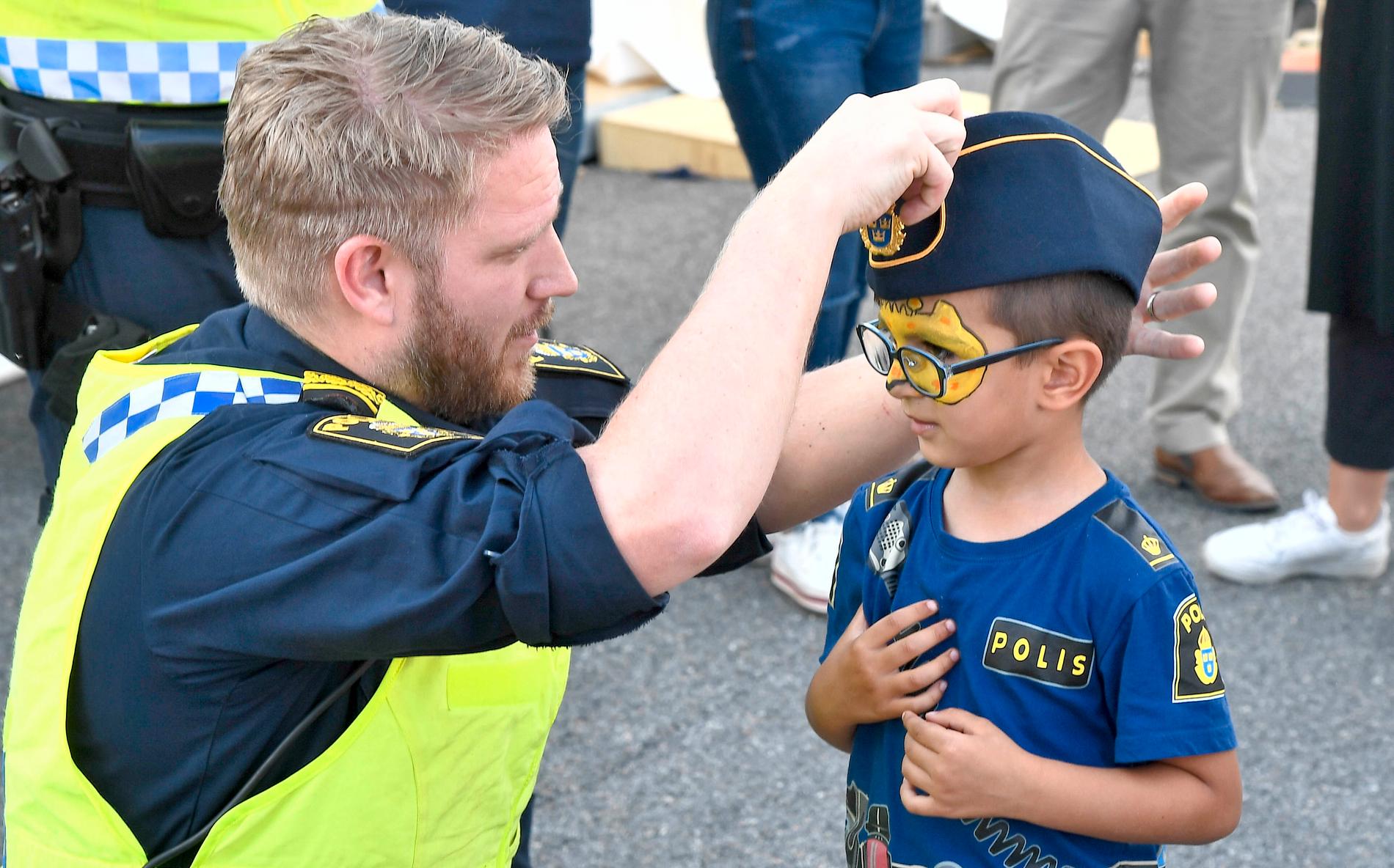 En liten polis får låna mössan. Politikerveckan på Järva är en mysig tillställning. 