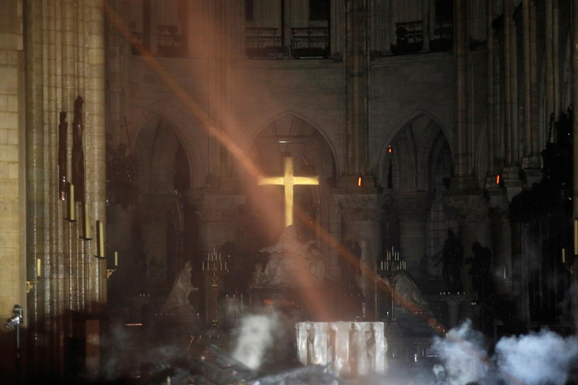 En av de första bilderna inifrån katedralen Notre-Dame efter branden. Rök syns framför altaret.
