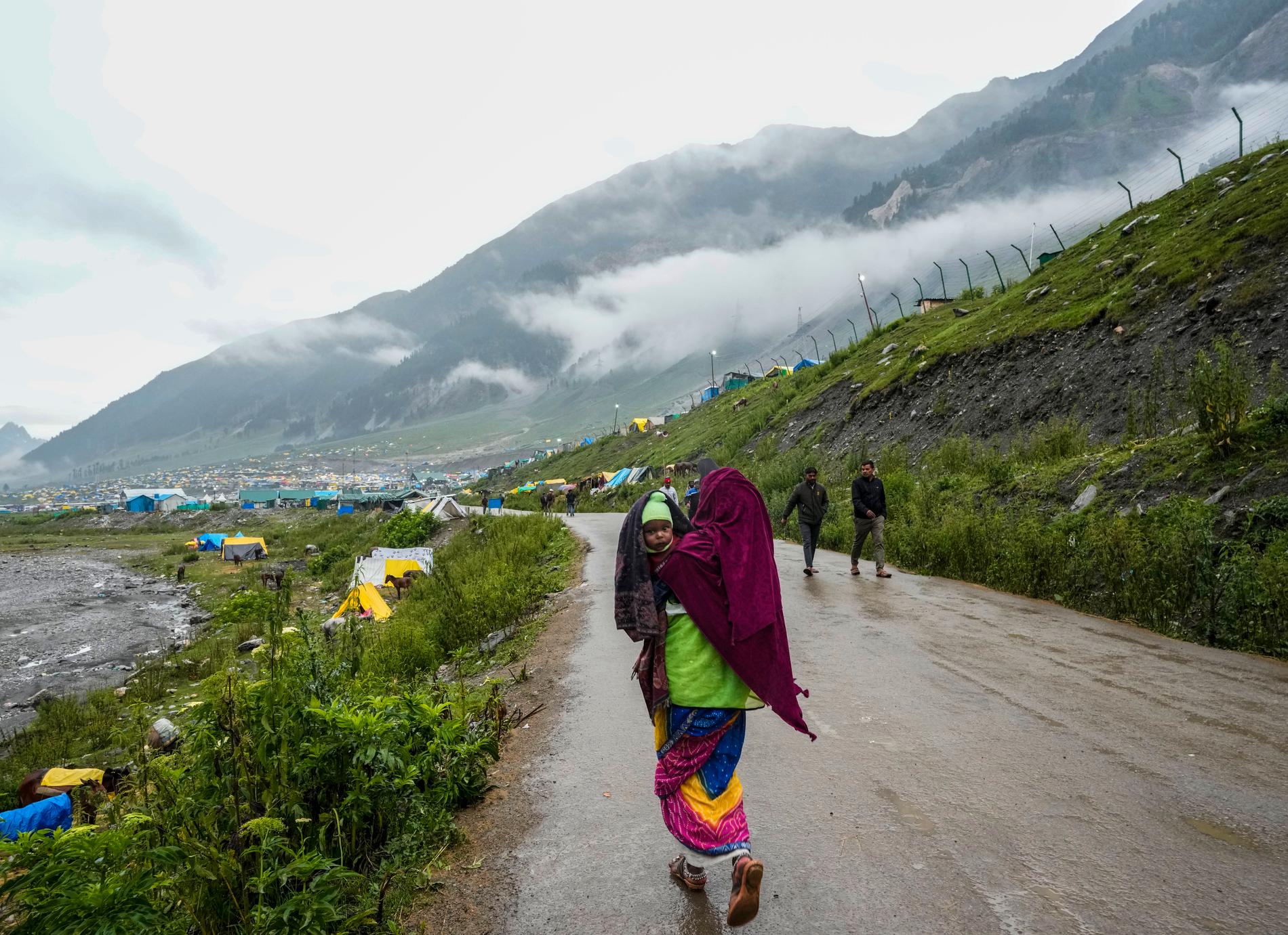En pilgrim återvänder efter att enorma vattenmassor svept med sig flera tältläger och dödat flera personer i Kashmir.