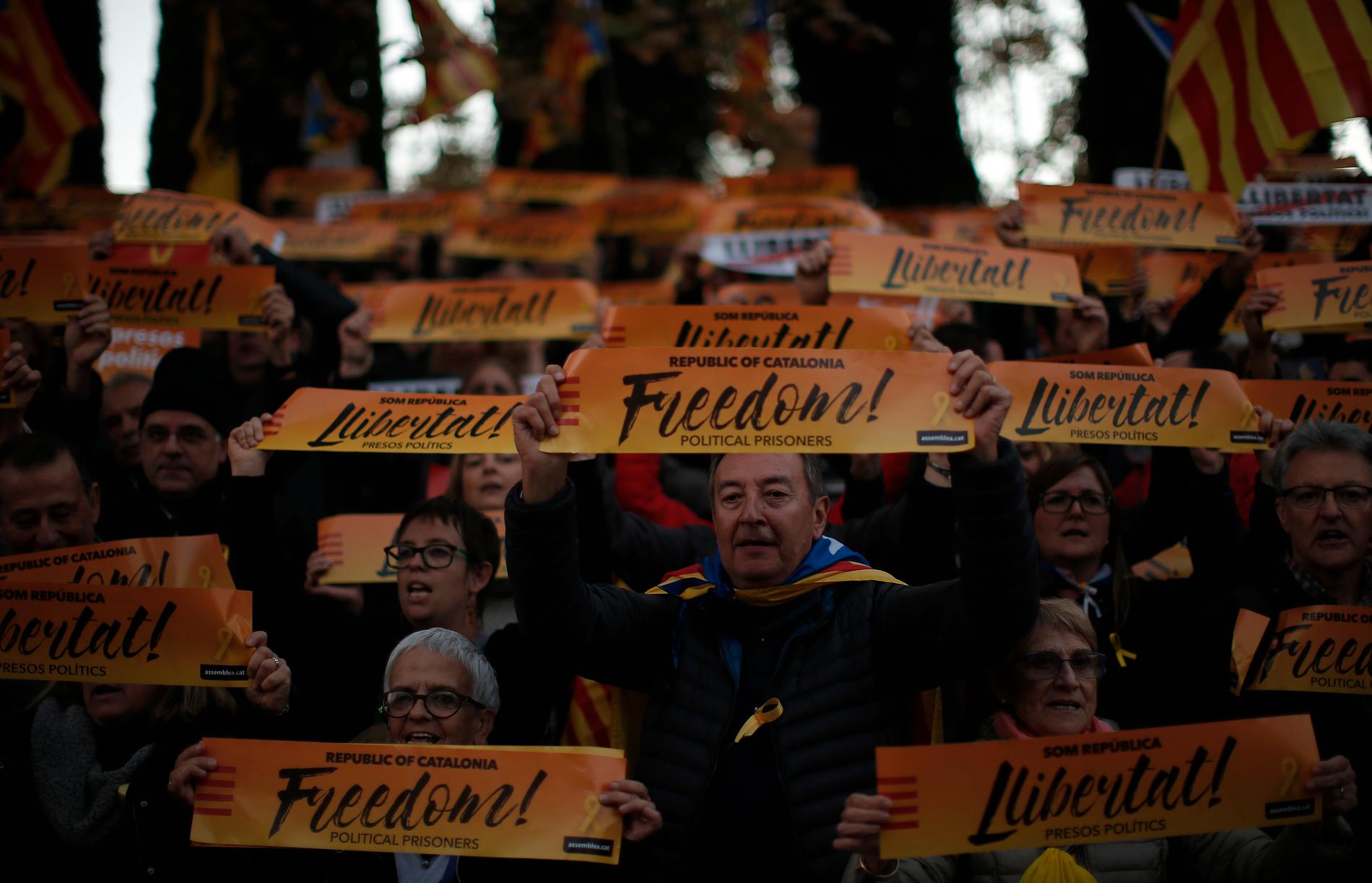 Demonstranter i Barcelona med banderoller med budskapet "Frihet!".