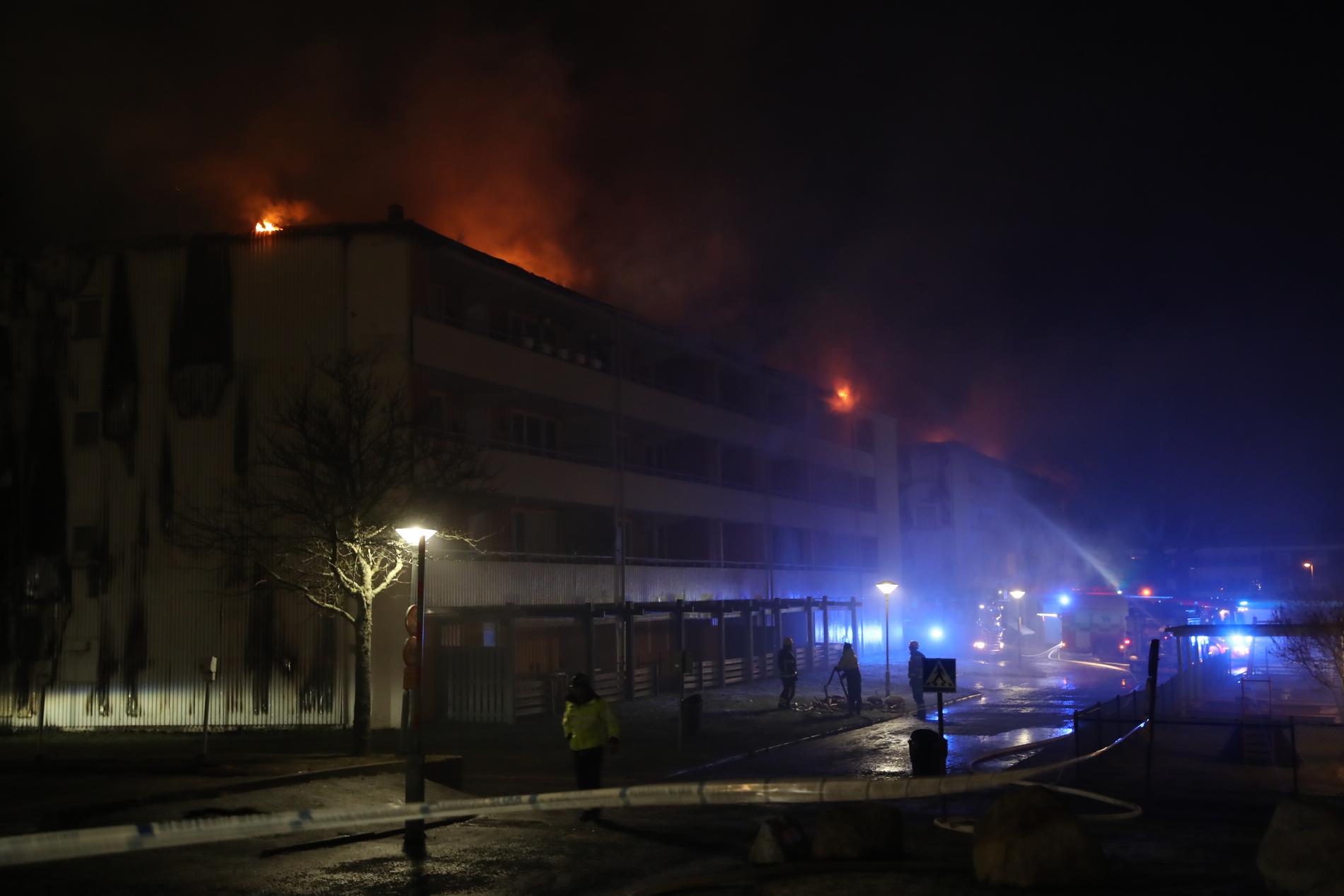 En kraftig brand rasar sedan tisdagskvällen i ett flerfamiljhus i Skövde. Boende i mellan 90 och 100 lägenheter har evakuerats.