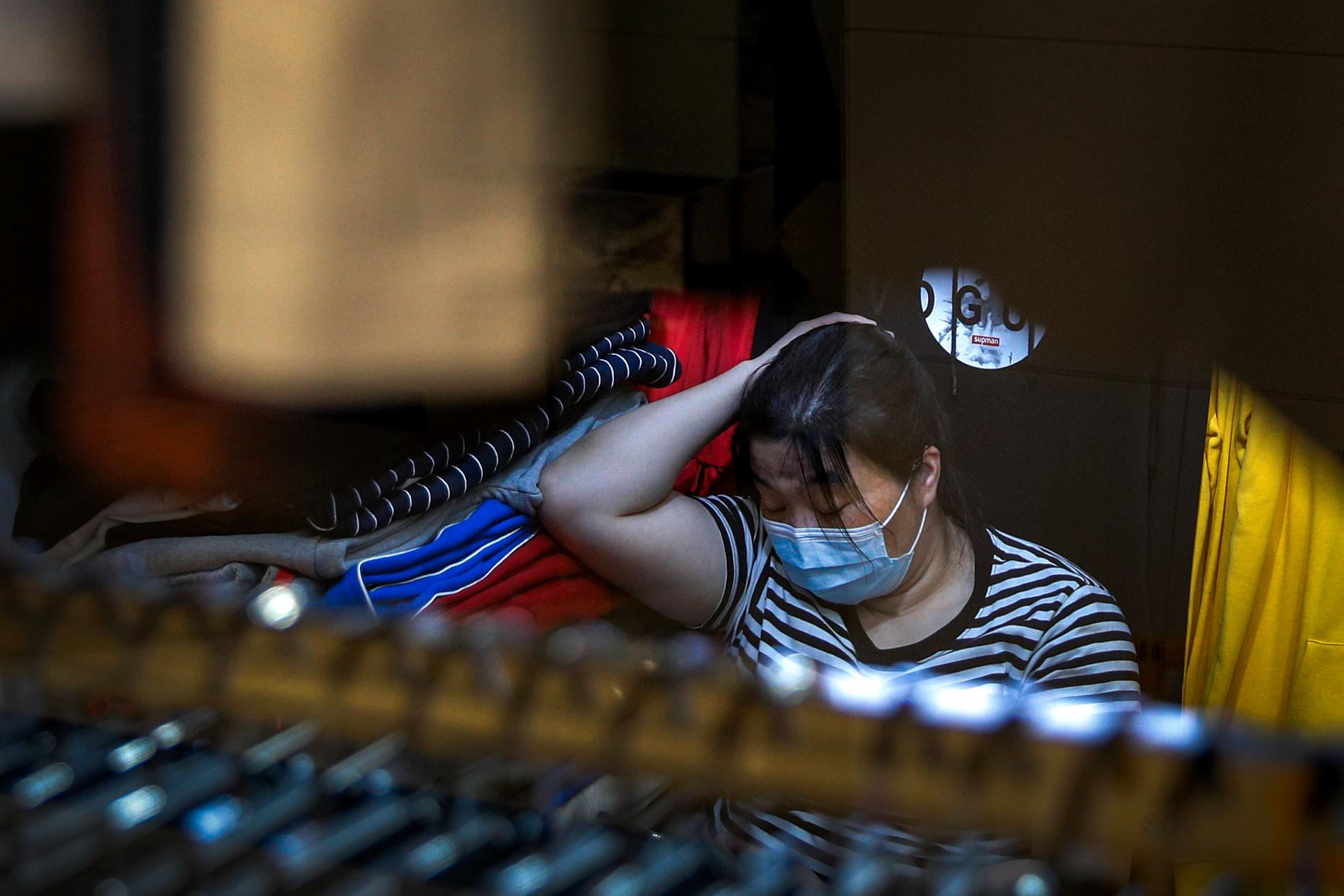 Affärsidkare i Peking tar en lur i sin butik på måndagen.