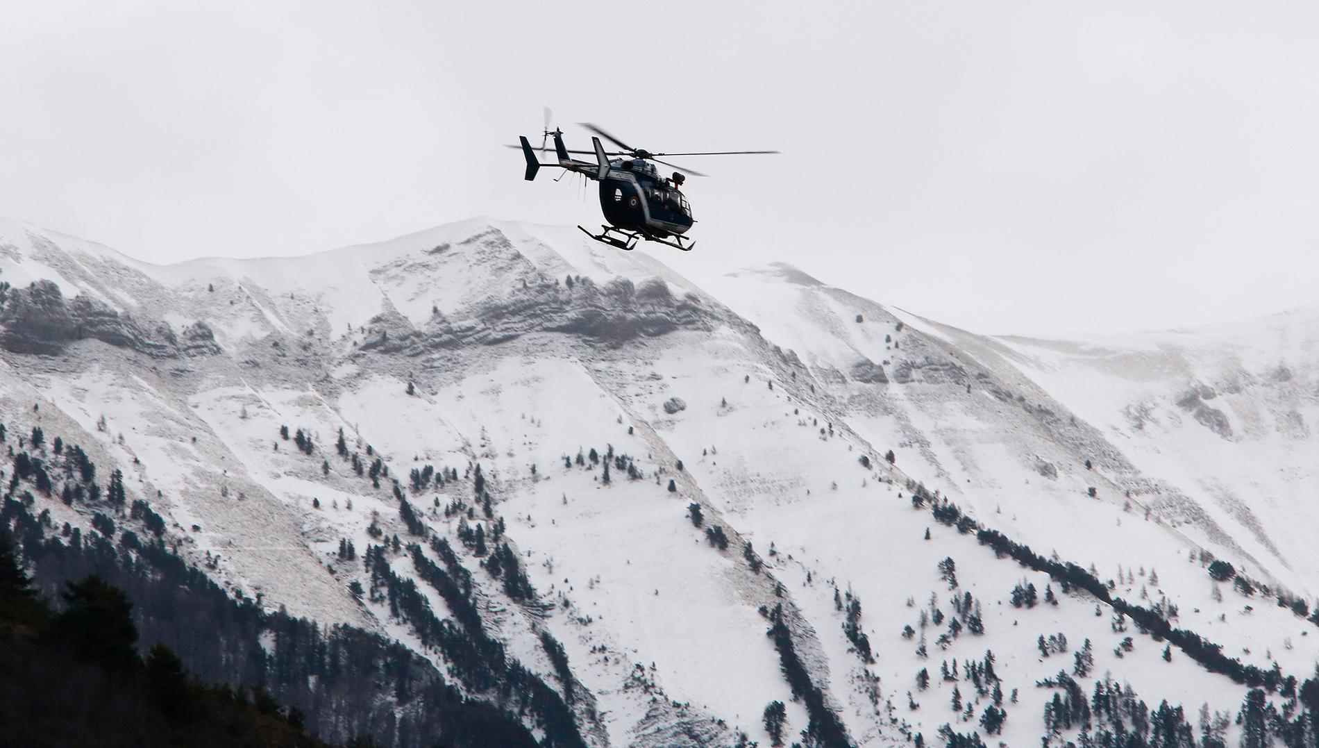 En fransk helikopter flyger i området kring platsen där planet kraschade.