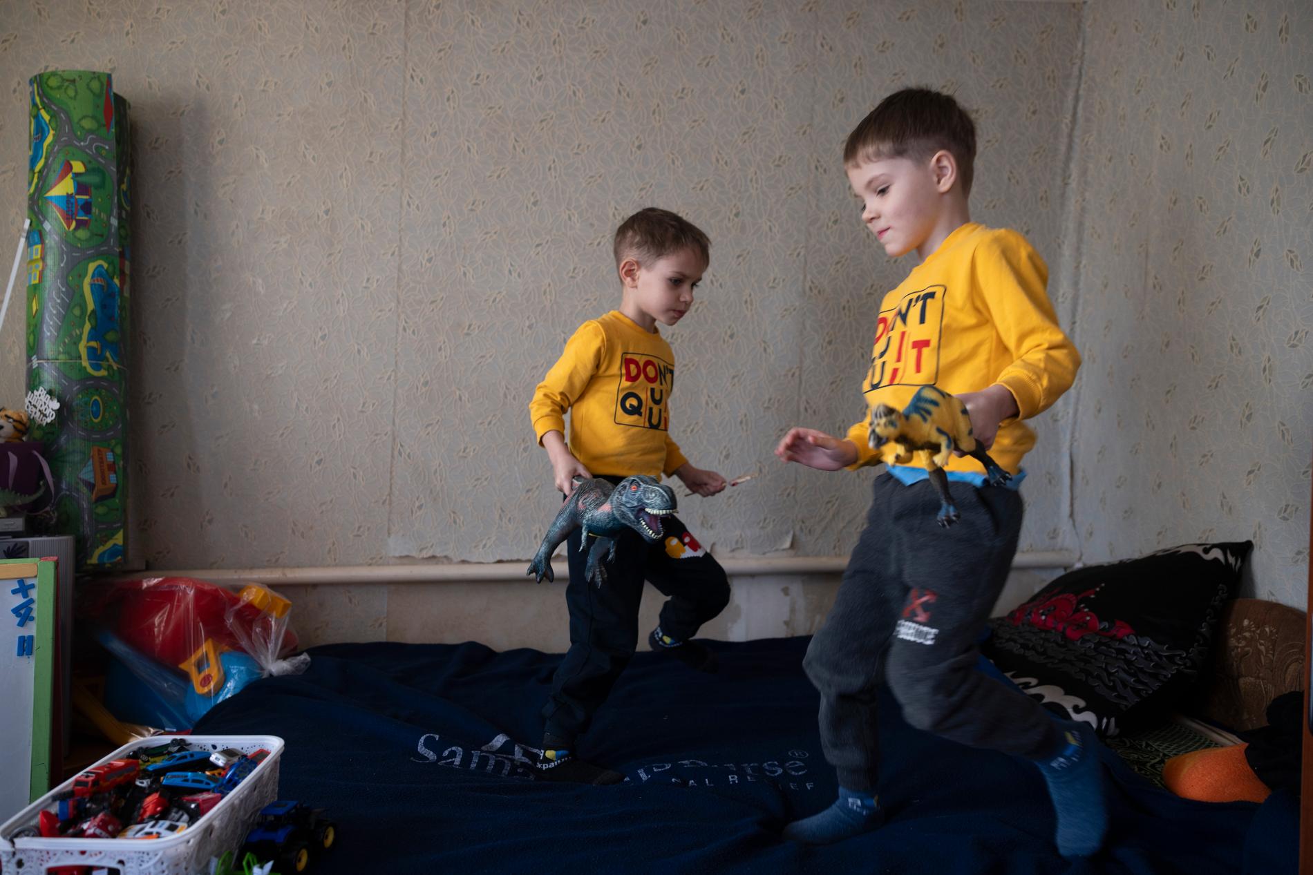Maksym och Yegor leker i familjens sovrum. 