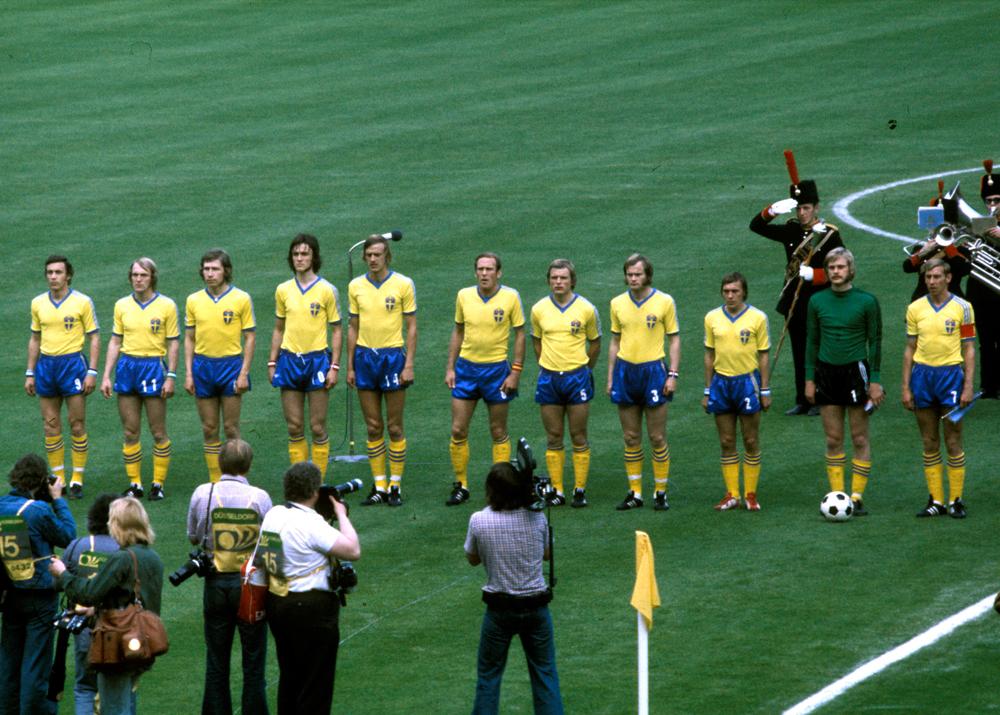 Det svenska fotbollslandslagets startelva lyssnar på nationalsången innan gruppspelsmatchen mot Bulgarien vid Fotbolls-VM 1974 i Västtyskland. Ralf Edström är fyra från vänster.